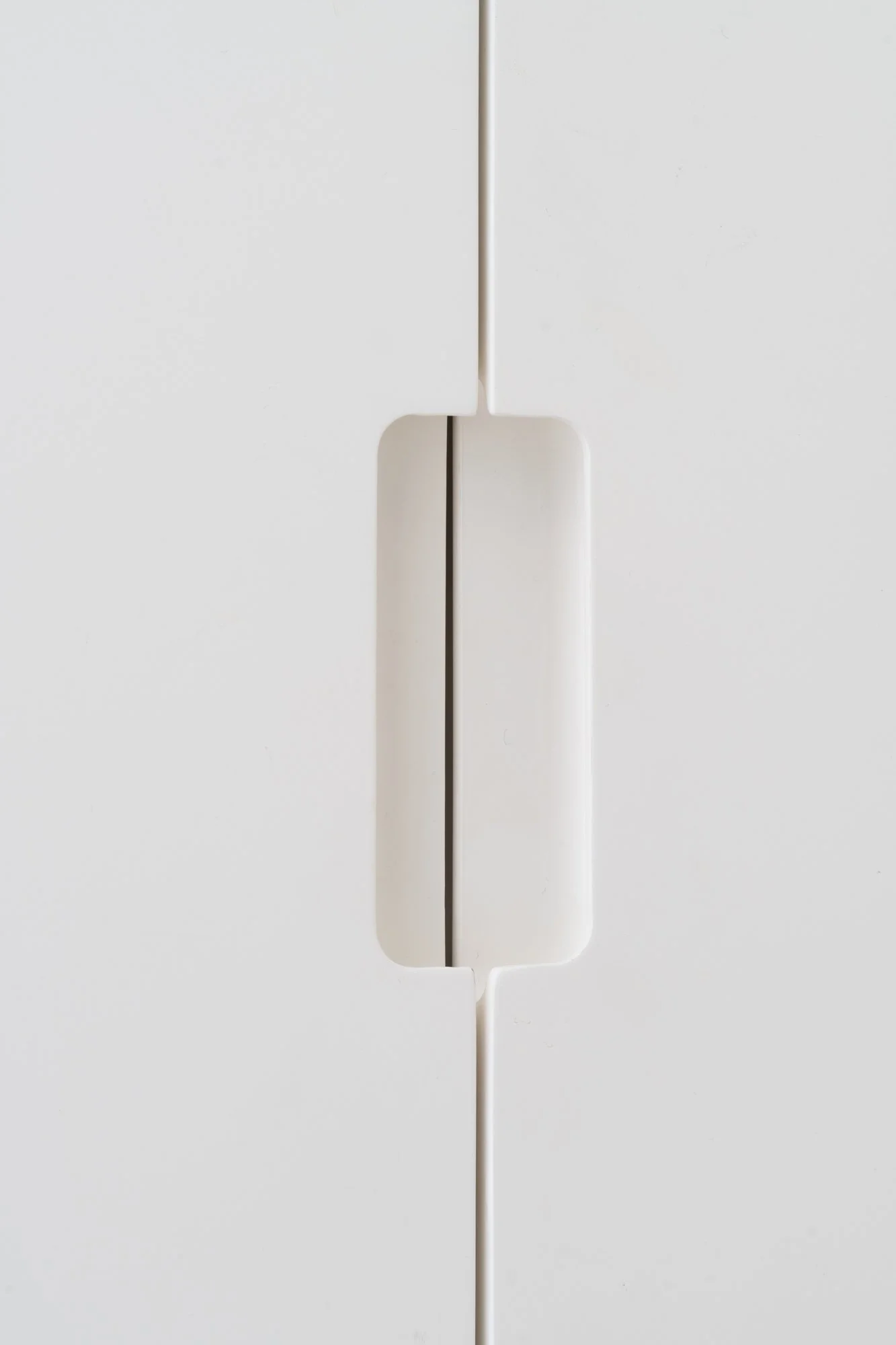 Detail of custom white cabinetry at Narrow Townhouse, showing integrated recessed pull handle.