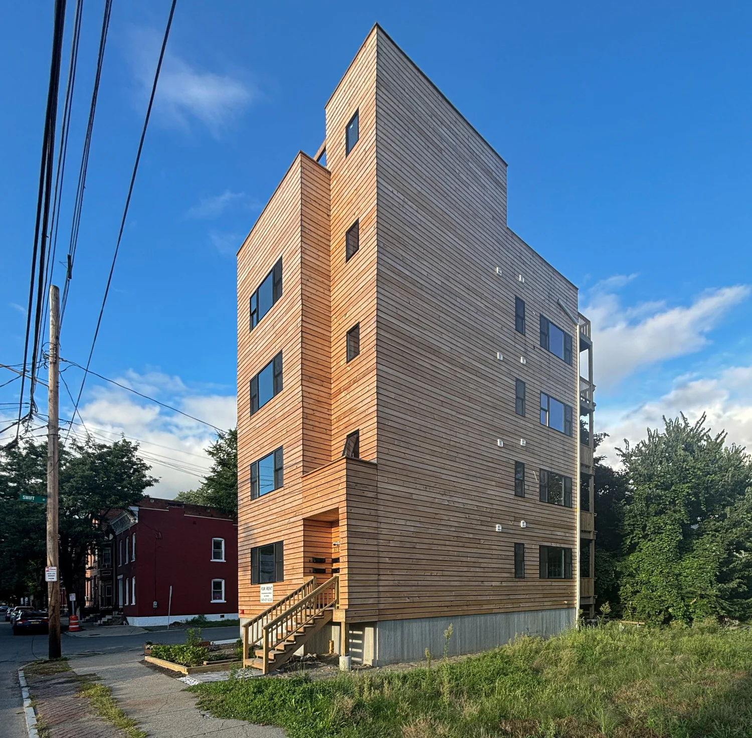 Timber-clad infill housing seen from the street