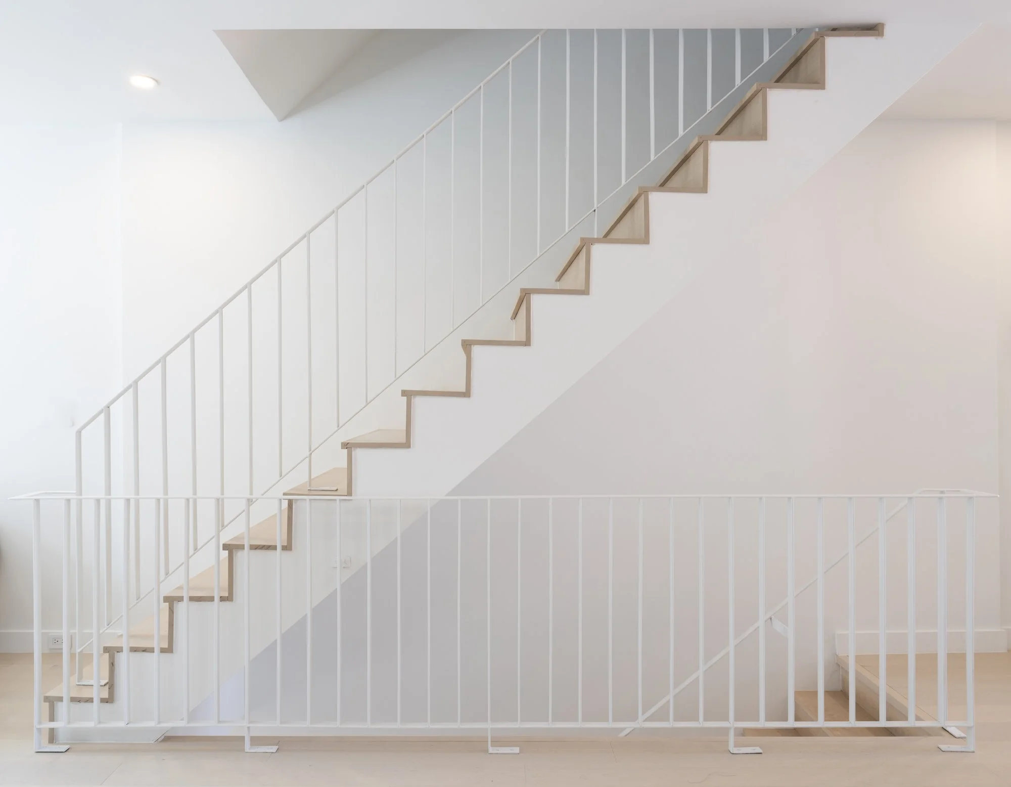 White-painted stair with slender vertical balusters, creating a clean and airy ascent.