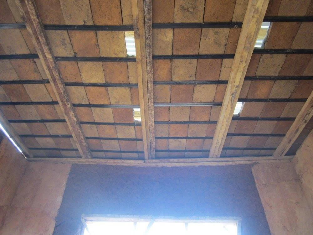 Interior view of the Mudhouse showing compressed earth block ceiling supported by timber framing.