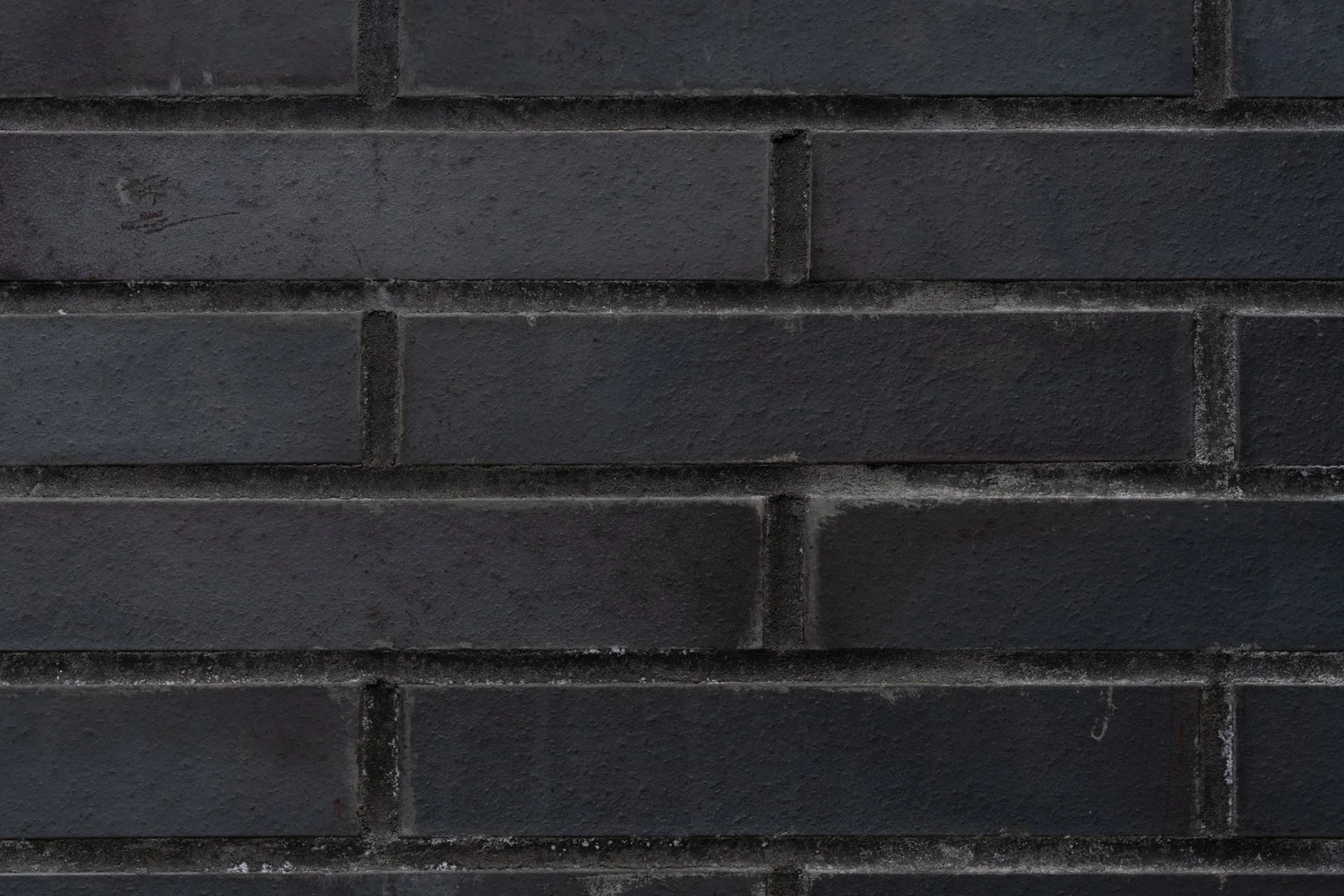 Close-up detail of Narrow Townhouse exterior showing dark brick façade material.