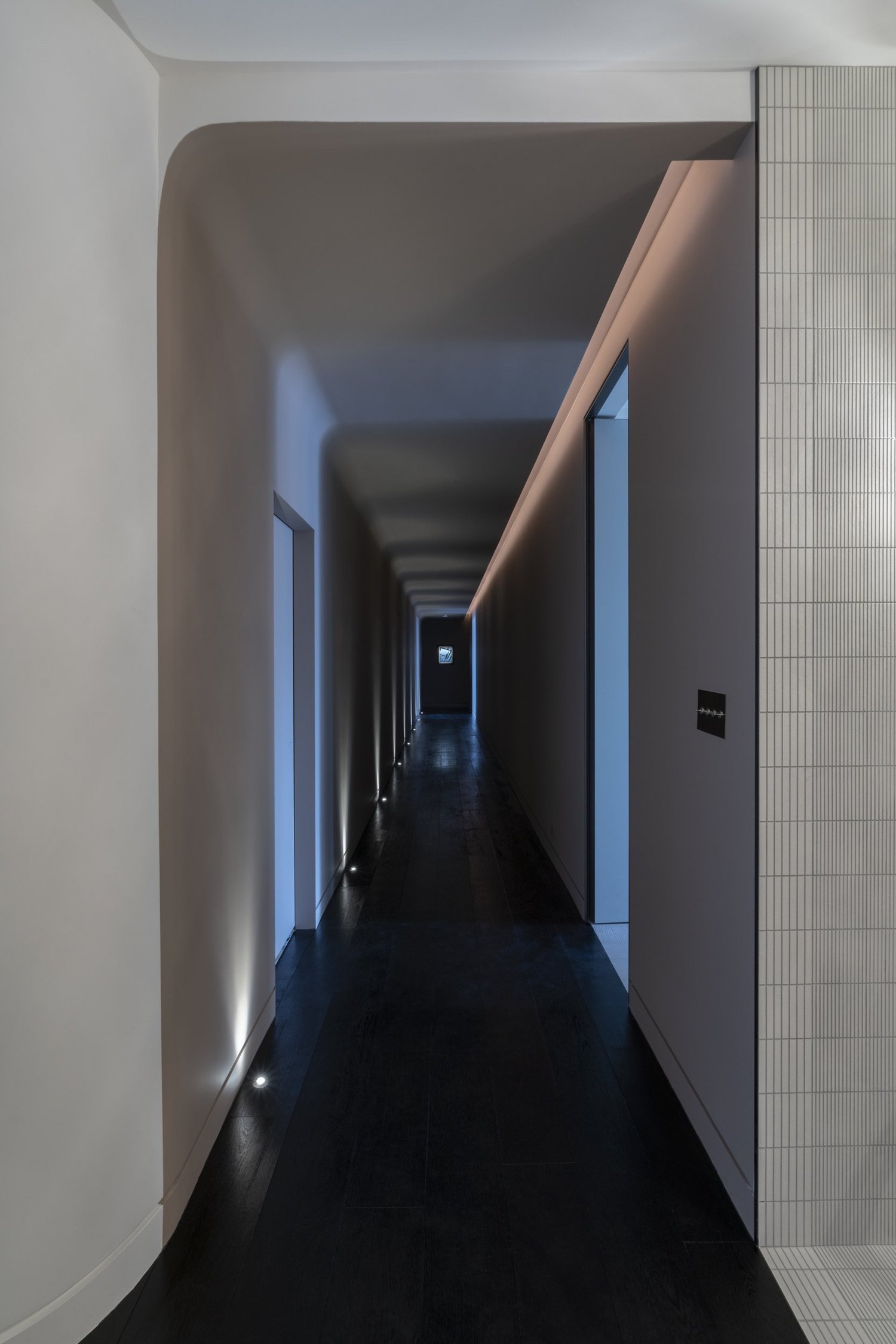 Cooper Square Lighthouse, long hallway with a curved ceiling and floor-mounted lighting