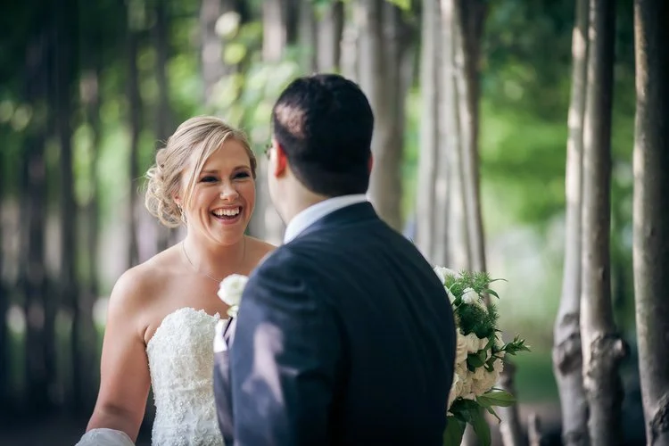 A bride and groom smiling as they see each other for the first time during their first look.