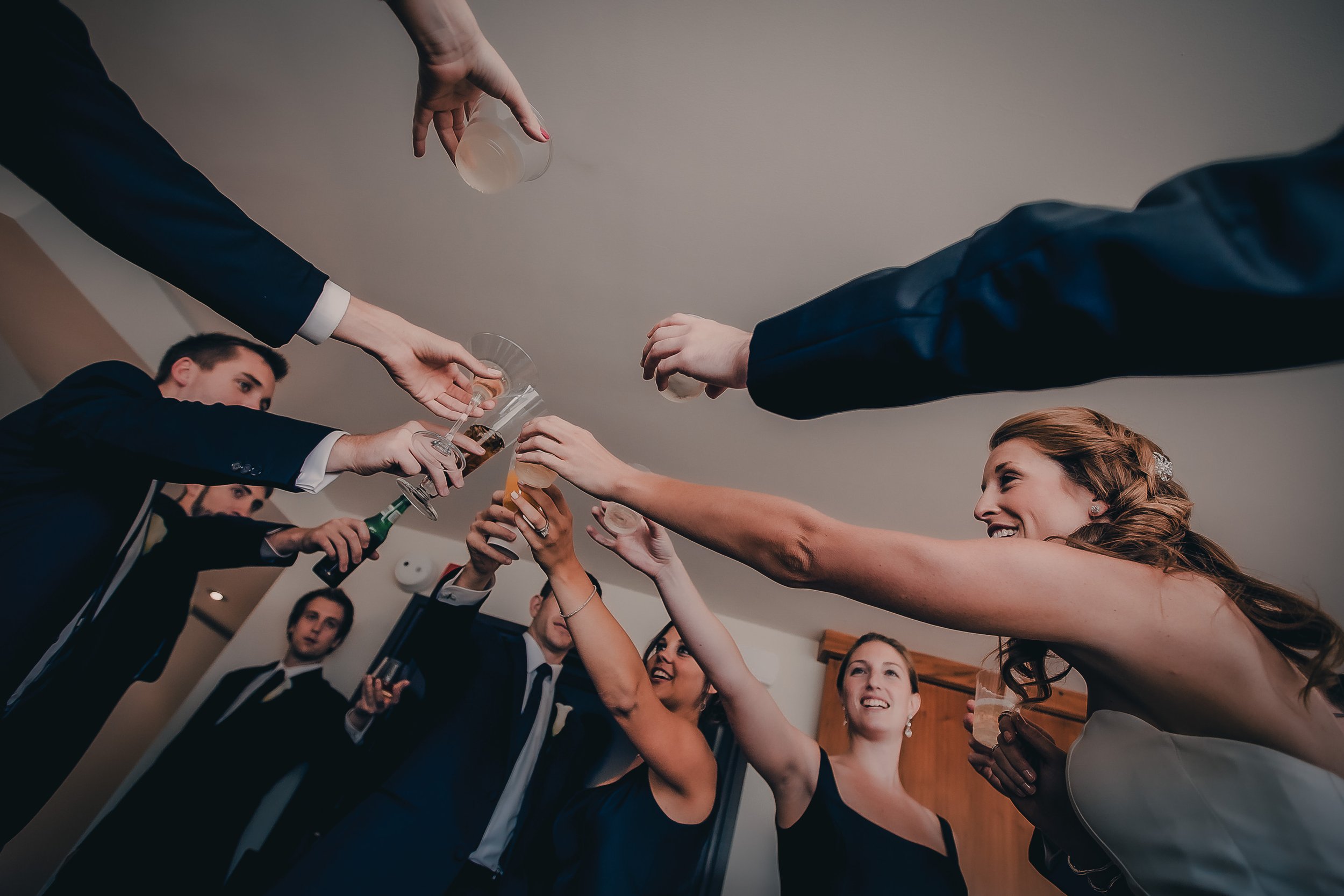 Group of people in formal attire clinking drinks at a celebration