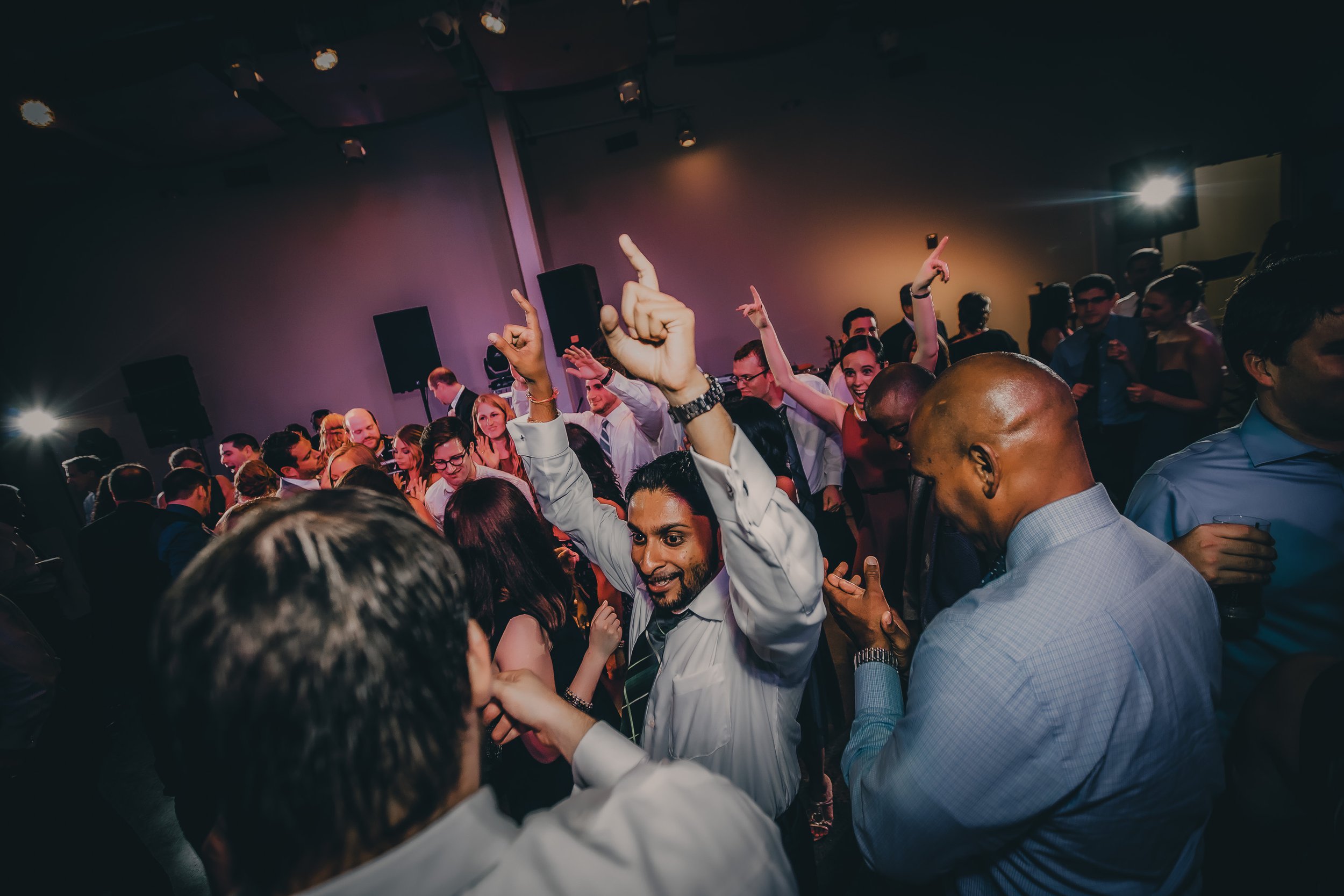 People dancing and having fun at a party in a dimly lit room.