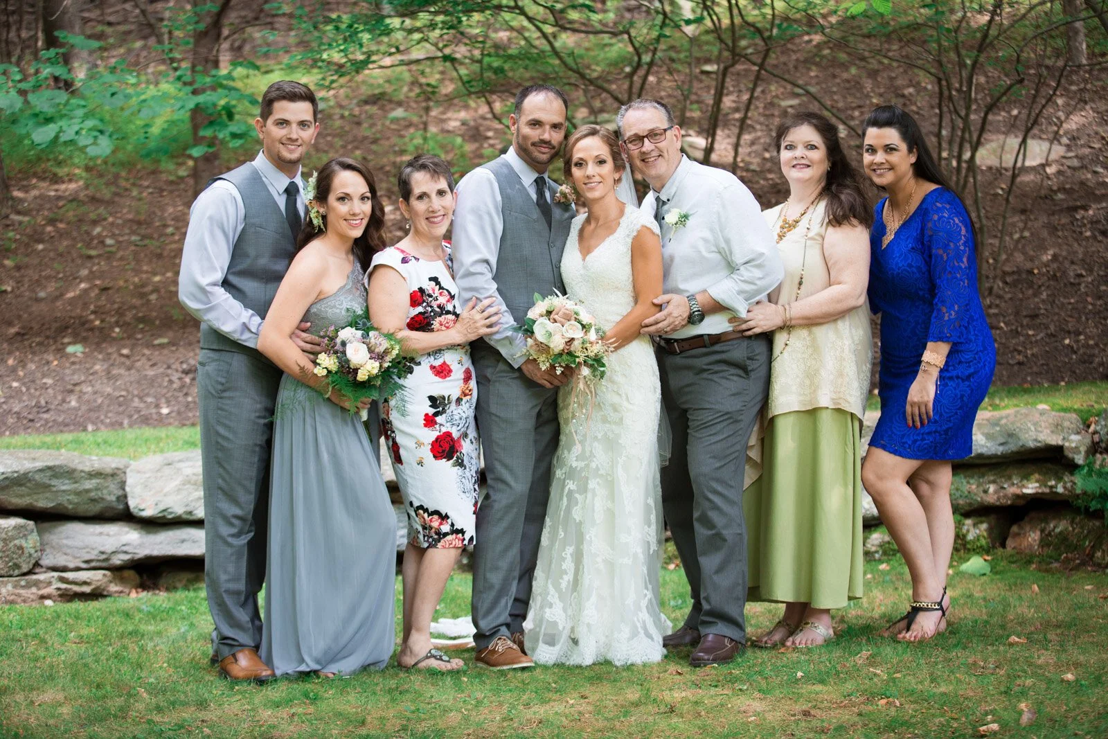A formal family portrait of a bride and groom and their respective families.