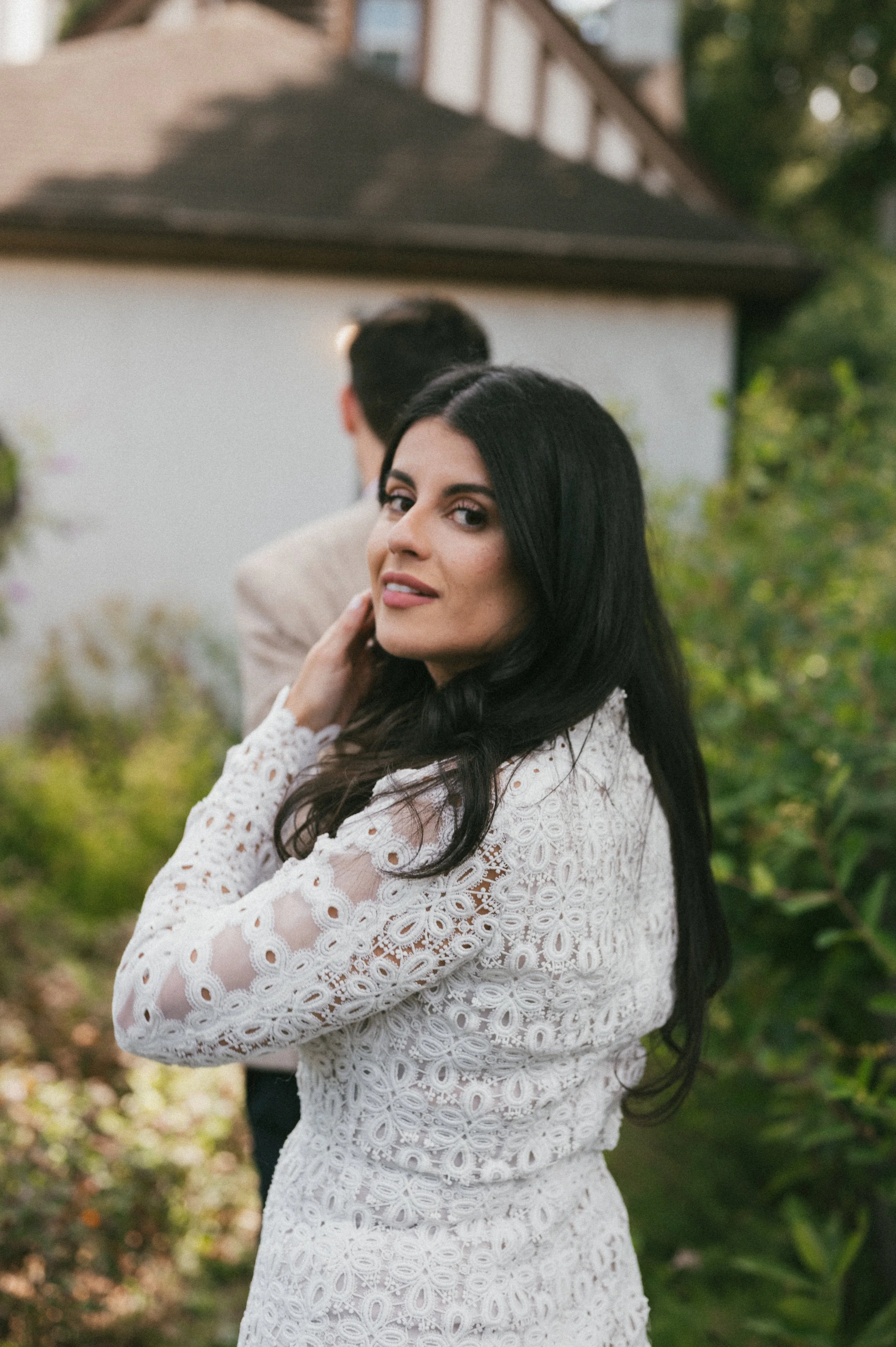 girl wearing white dress looks back at camera during engagement photos