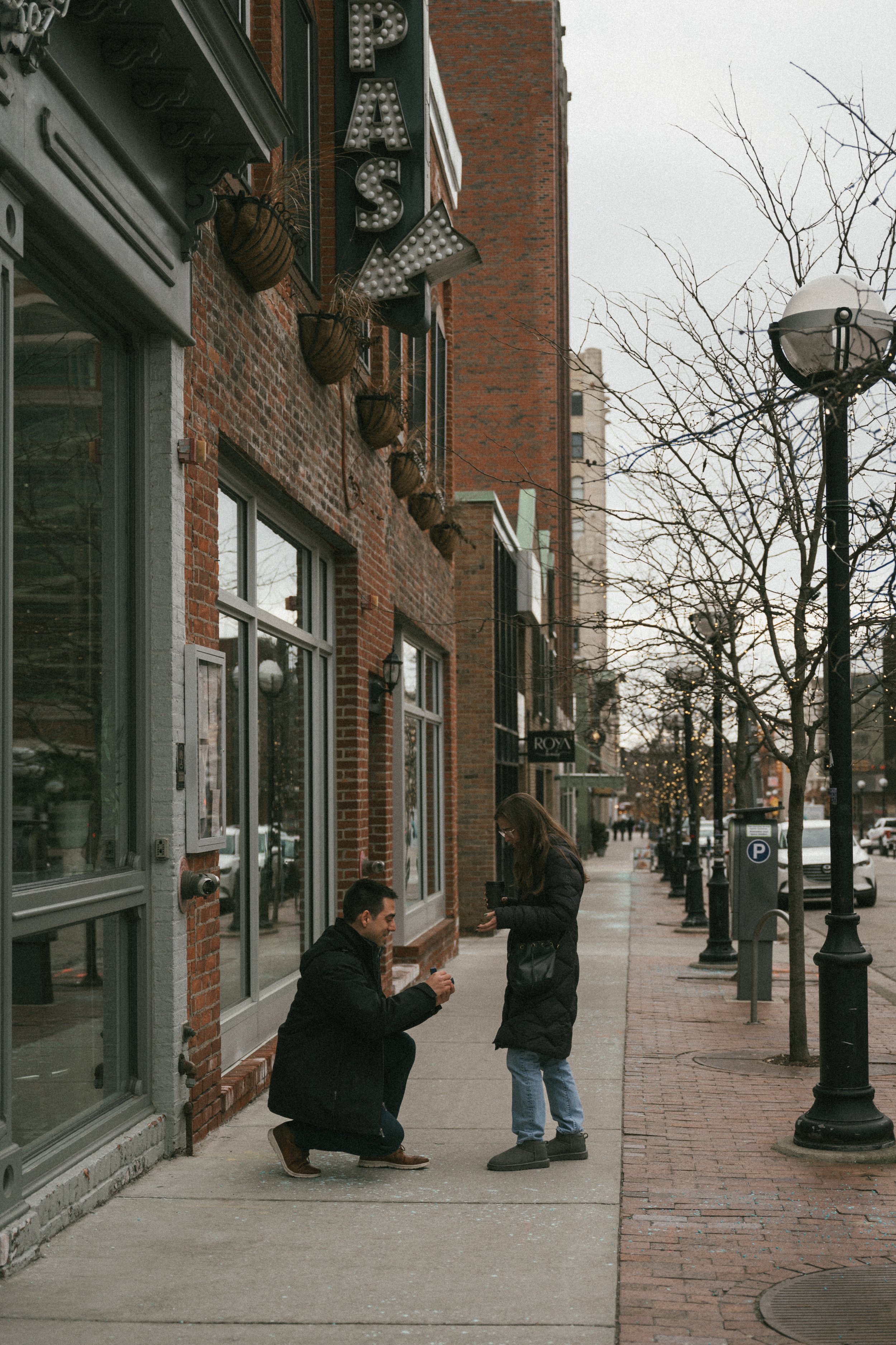 Man proposes to his girlfriend outside Aventura restaurant in Ann Arbor in the winter