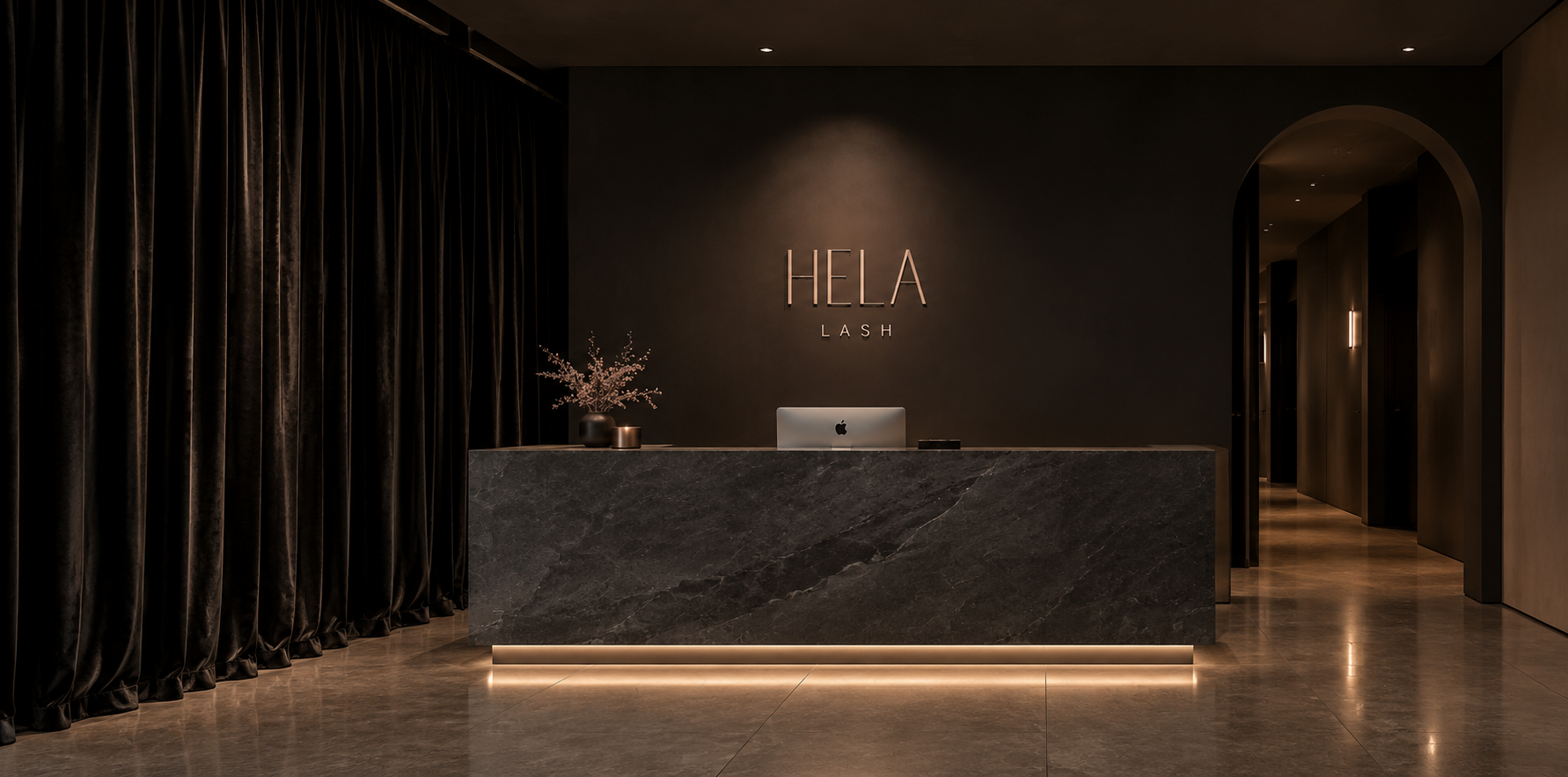 Reception desk at Hela Lash salon with a black marble counter, a computer, decorative vase with flowers, and 'HELA LASH' sign on a dark wall.