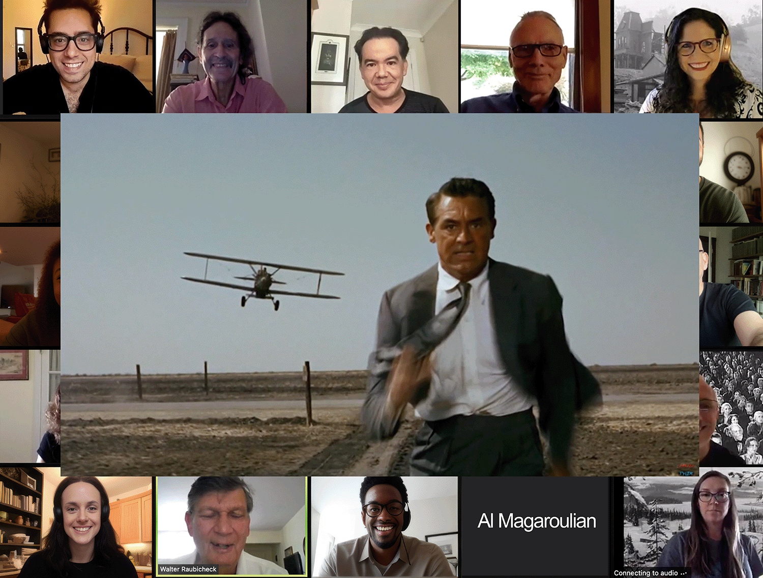 A video conference screen shows multiple participants in a grid with a scene from a film or TV show in the middle. The scene features a man running on a dirt path with a biplane flying overhead and a vast, open landscape in the background.