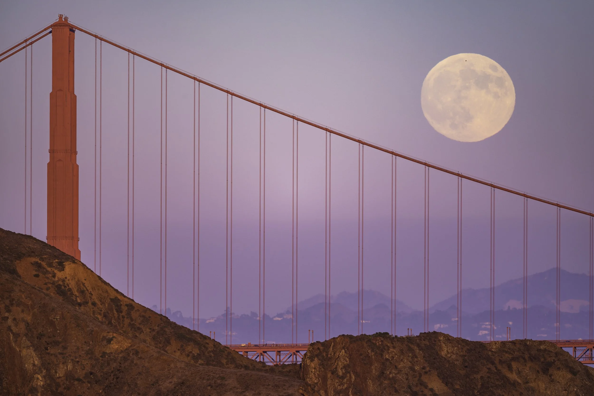 The harvest moon rises above the Golden Gate Bridge in San Francisco on October 16, 2024.