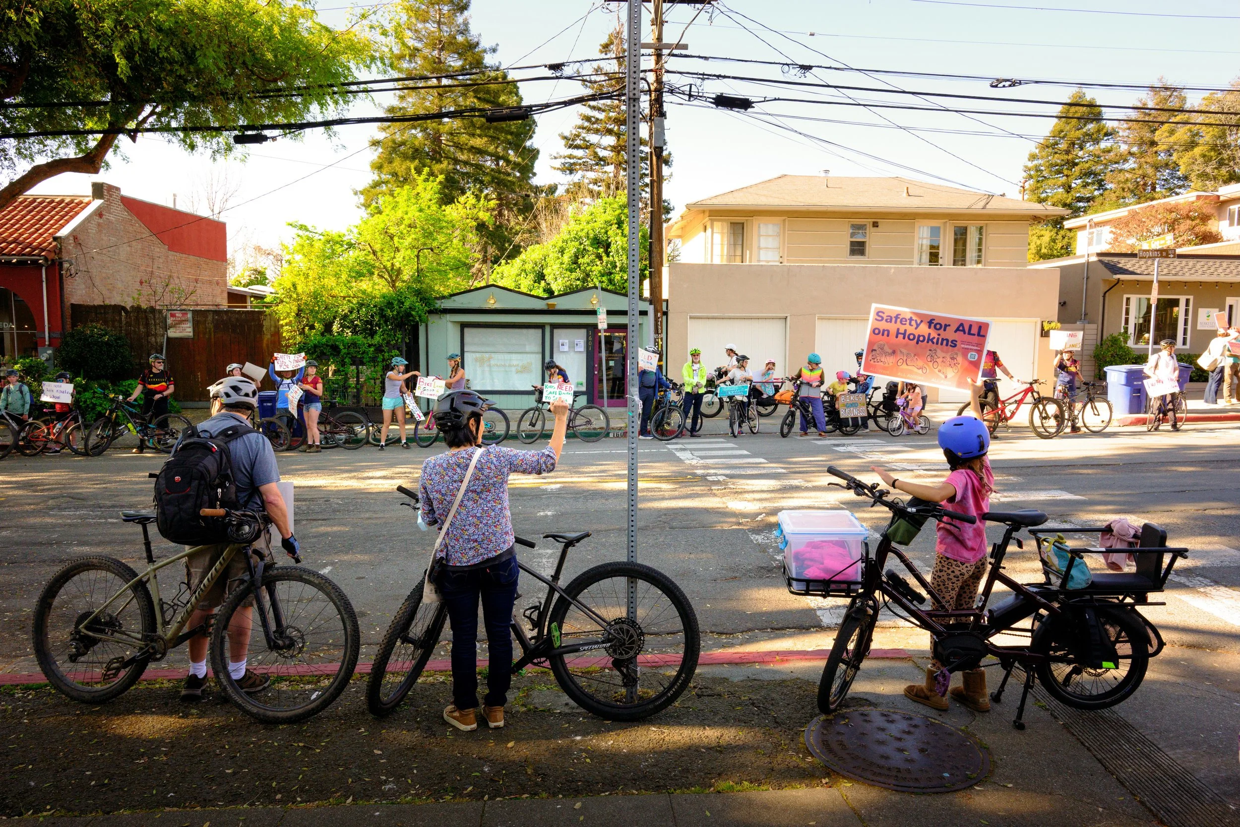 Cyclists line Hopkins Street in Berkeley, CA in support of a project to add a bidirectional cycle track on one side of street, a contentious issue within an aging community worried about preserving parking.