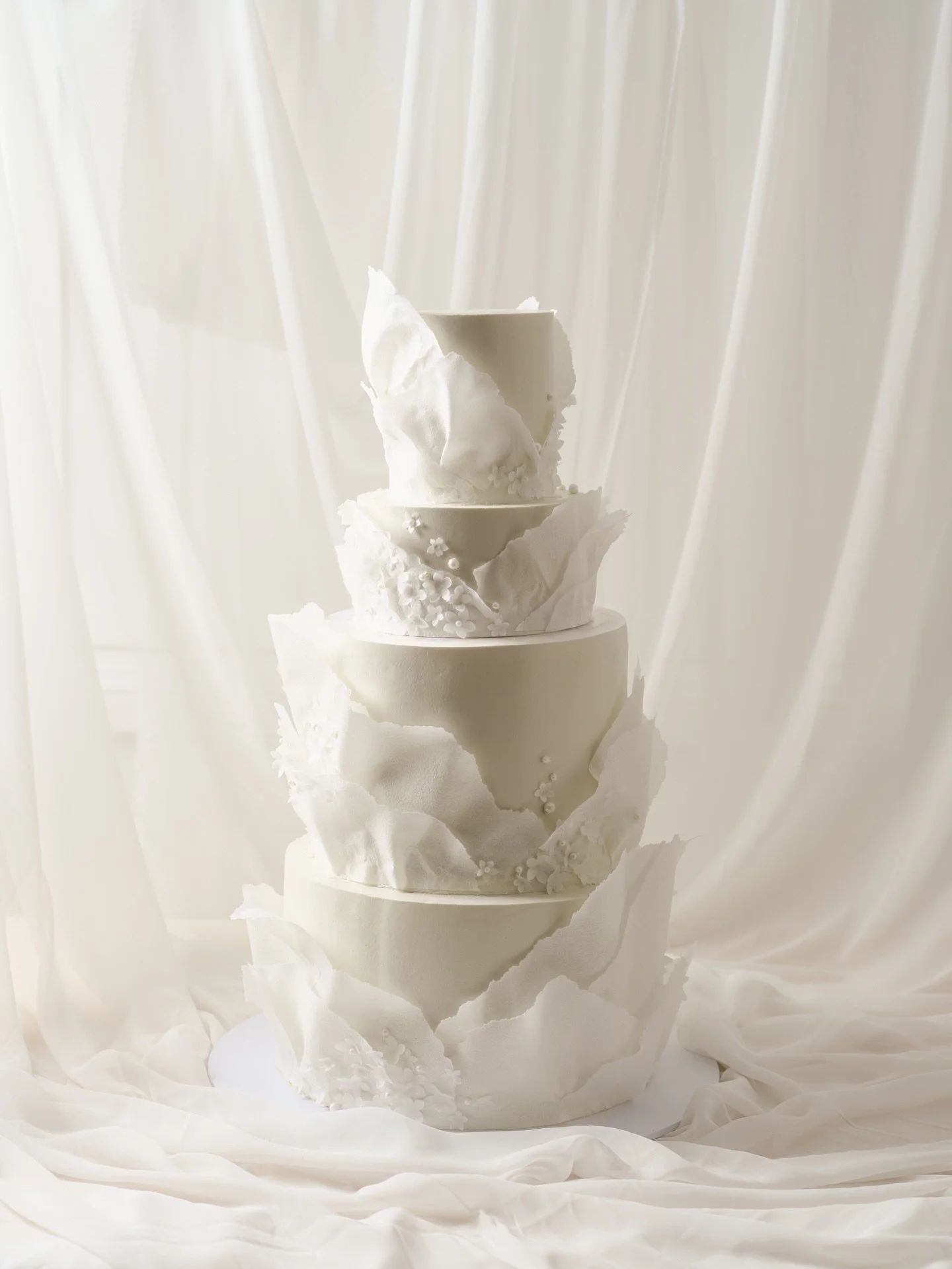A towering four tier cake with flowing wafer paper ruffles, delicate flower details and white pearls for Alex and Christine&rsquo;s wedding 🤍

#wedding #weddingcake #weddingcakes #weddinginspiration #cakedesign #floralcake #sydneycakes #sydneyweddin