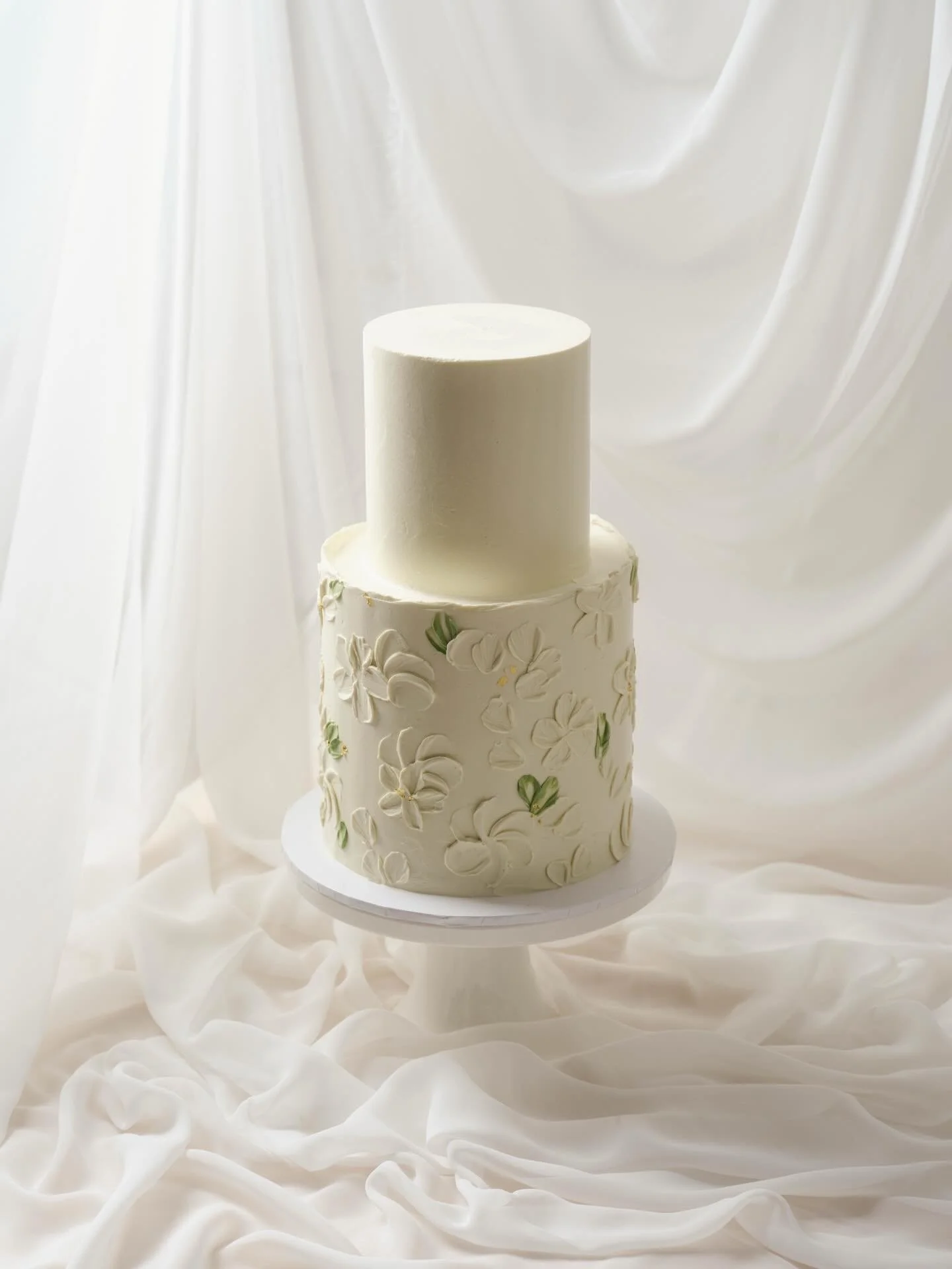 Two tiers of floral details and a touch of soft green for Jacinta and Tyler 🤍🌿

An intentional, but subtle contrast between a clean top tier finished sharp and smooth, with a bottom tier finished with a deckled edge and textured floral design. 

#w