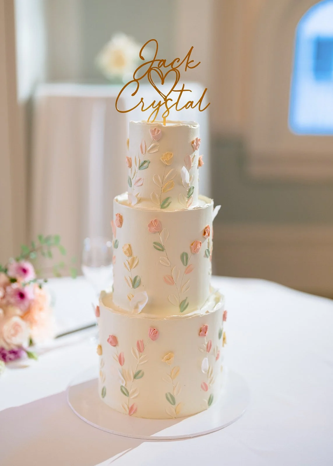 Three tier wedding cake with gold topper and pastel floral buttercream design - photo by Pepper June