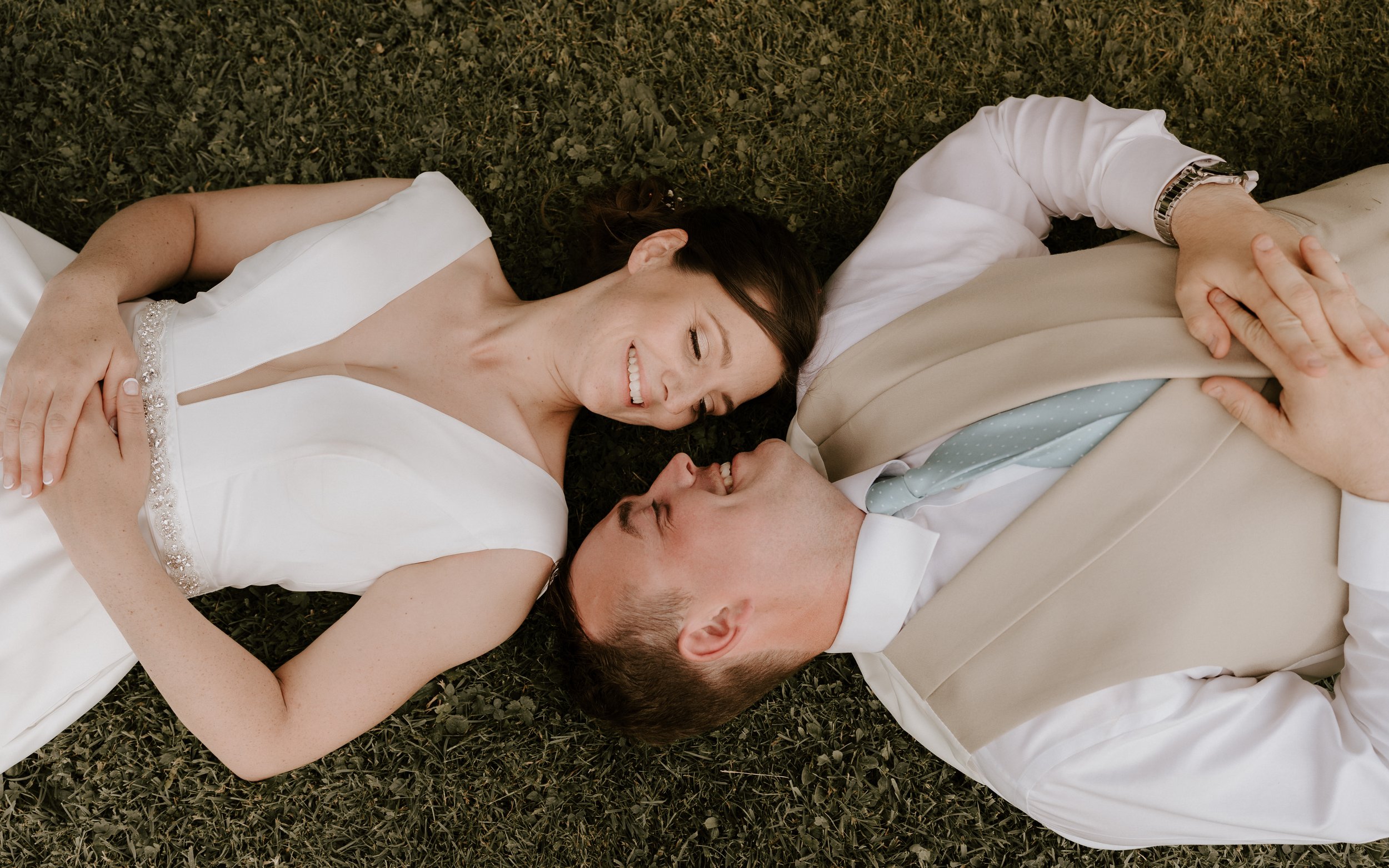 bride and groom laying on the floor sharing an intimate moment