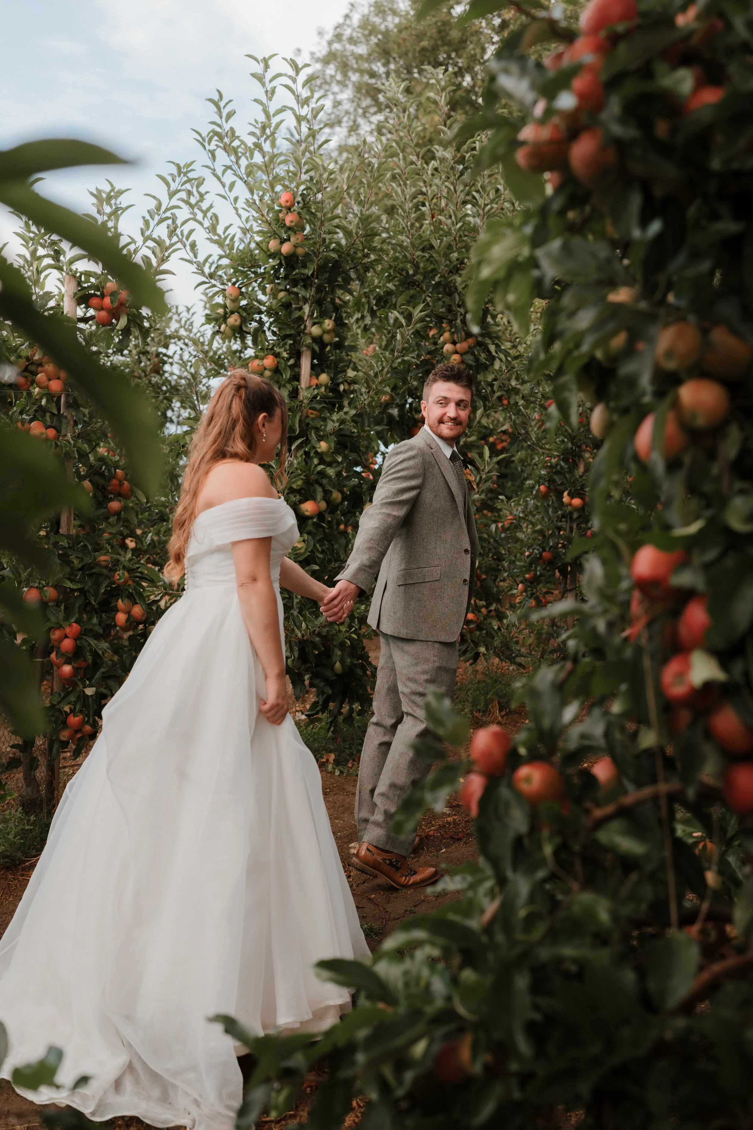 bride & groom walking through the vineyards at the barnyard
