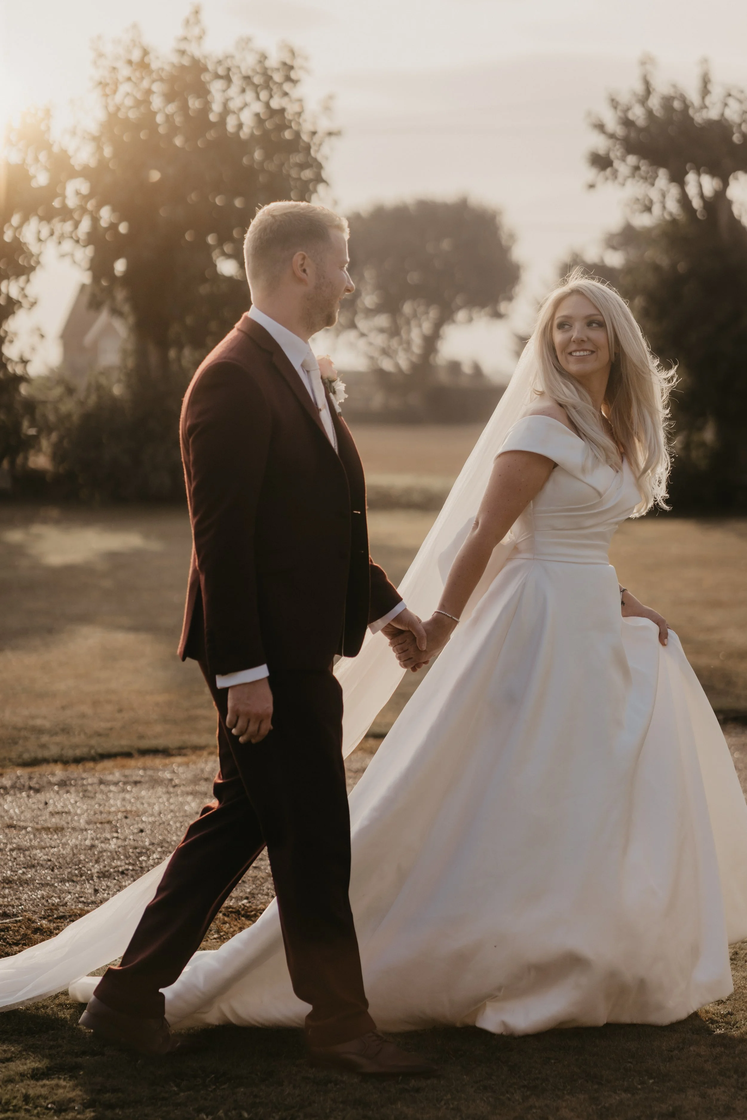 bride and groom walking in golden hour