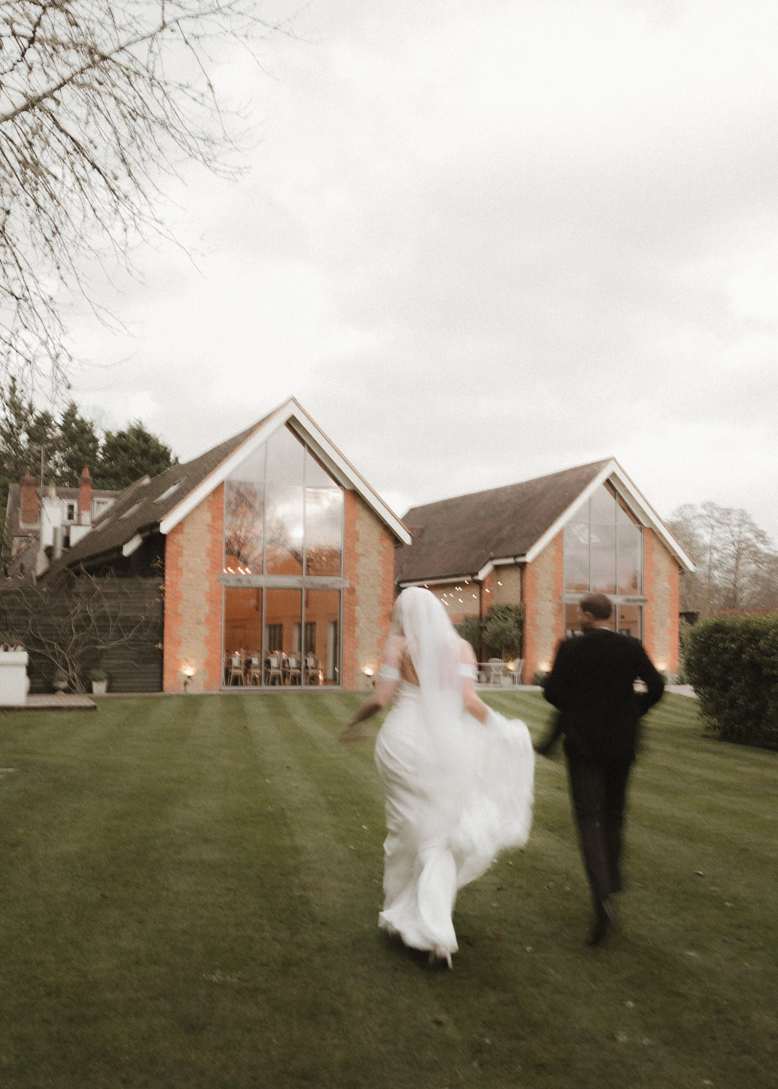 bride and groom running towards wedding venue with a blur effect