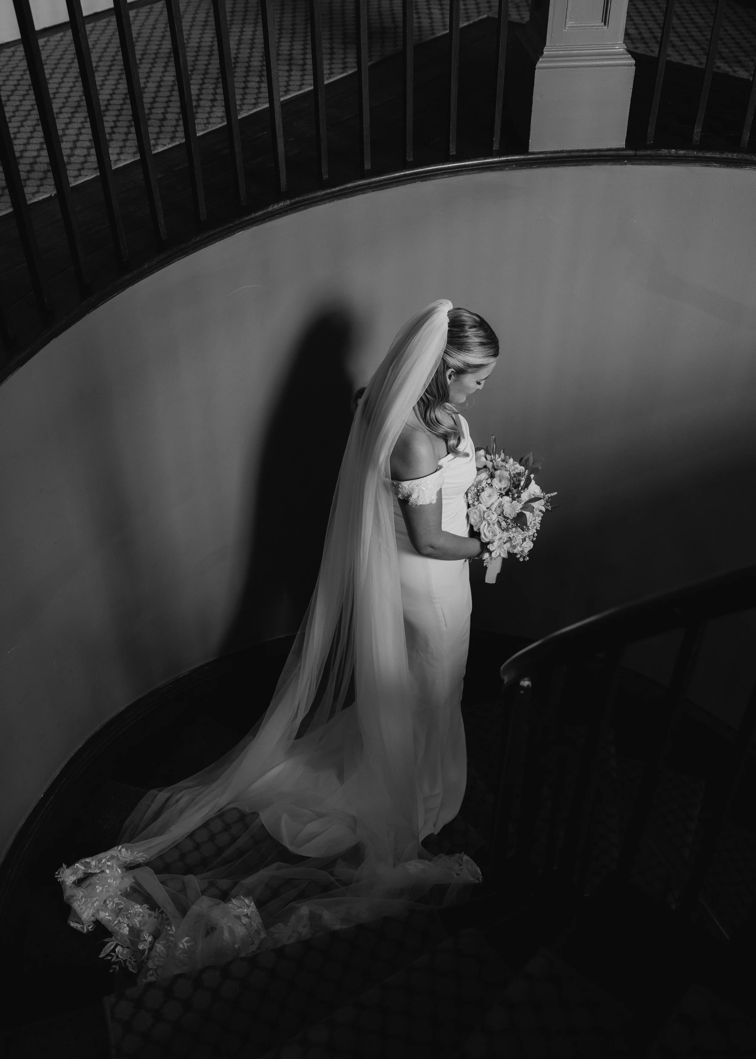 bride walking down the stairs of glewstone court with her veil behind her