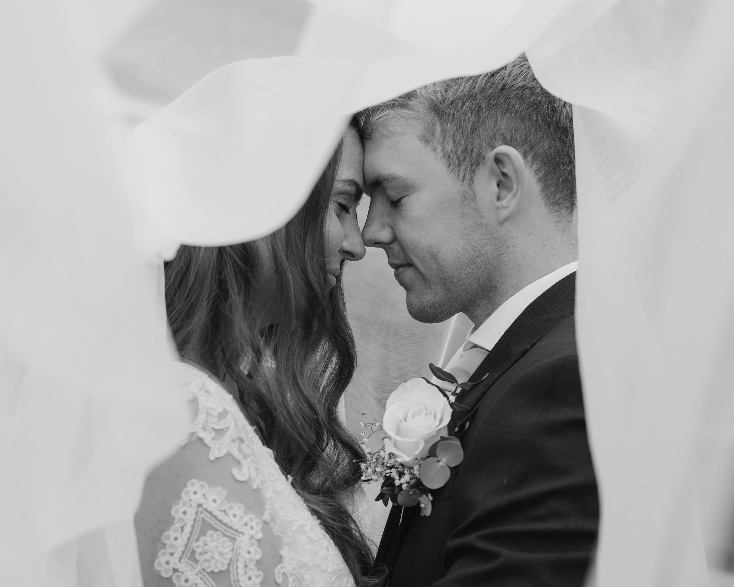 bride and groom sharing an intimate moment under the veil