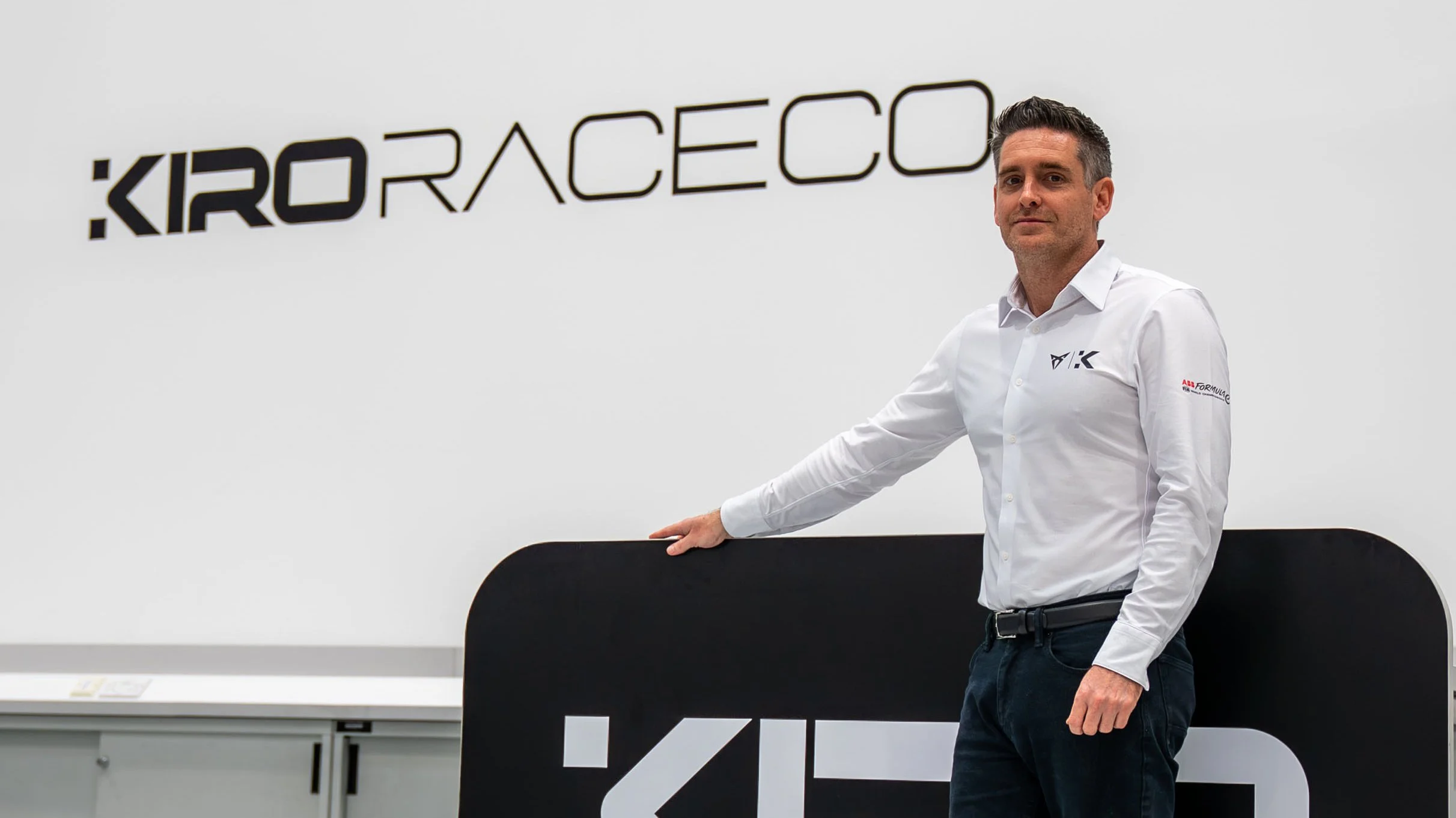 CURPA KIRO Team Principal in front of the team logo