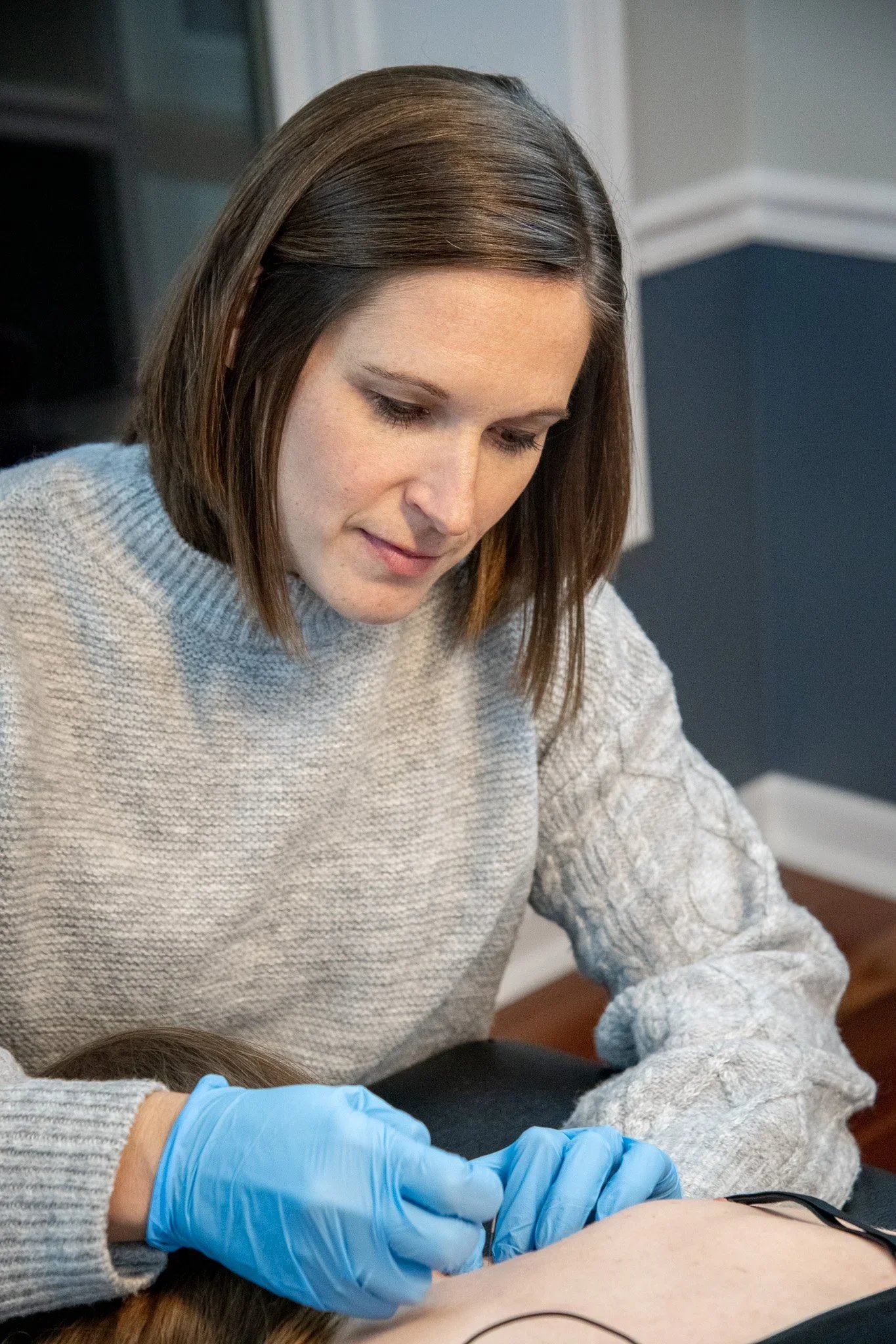 Sarah Meuler, PT dry needling a patient with electrical stimulation
