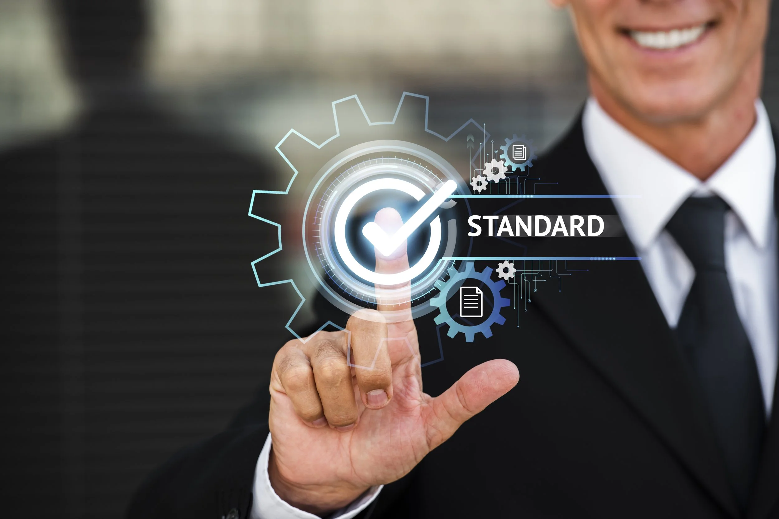A man in a suit touching a futuristic digital interface with a checkmark and the word 'STANDARD' on a transparent screen.