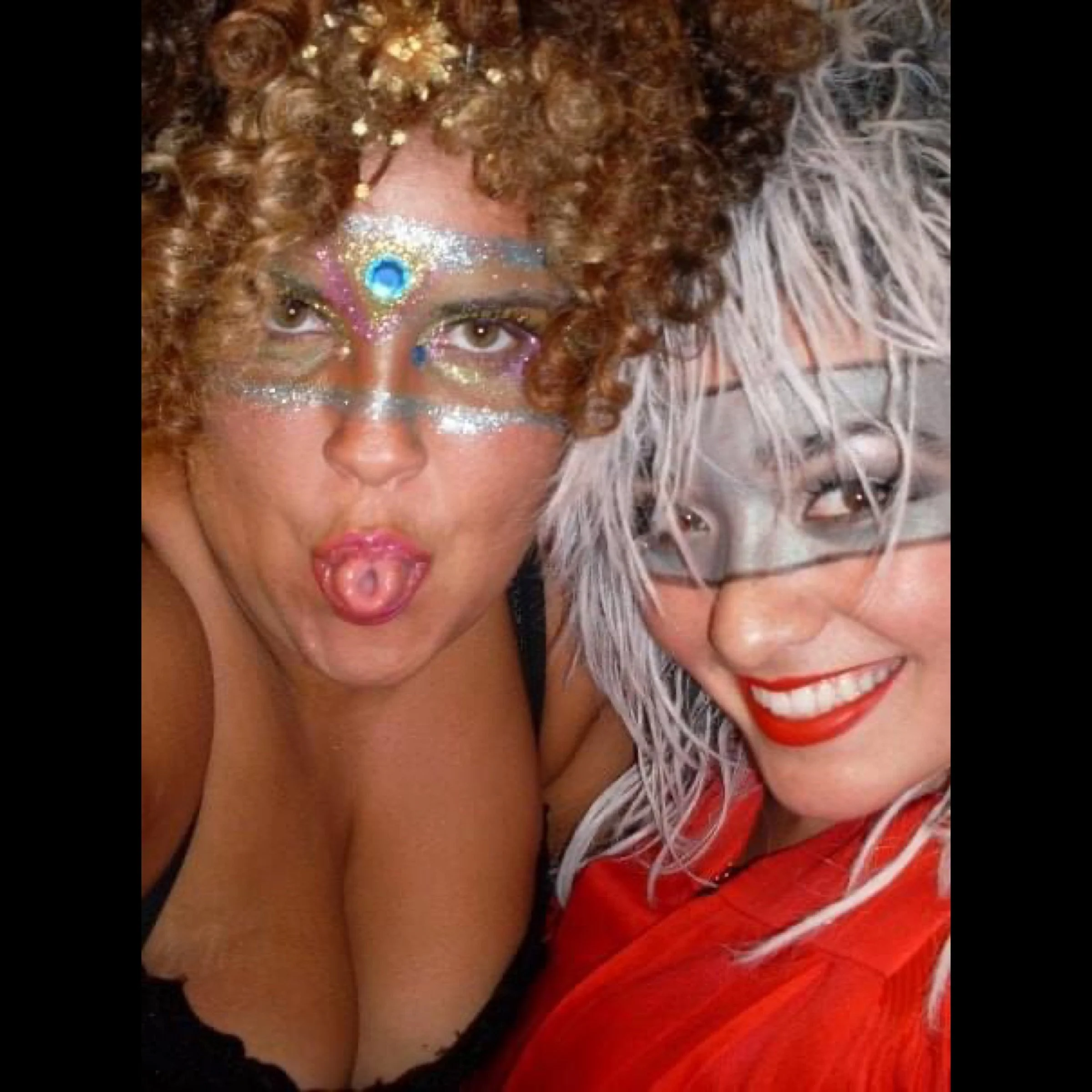 ROCKY HORROR SHOW AT Manoa Valley Theatre. Actress Cassie Favreau-Chung plays Magenta. Two women with colorful metallic masks and bright makeup, smiling and posing close together for a selfie.