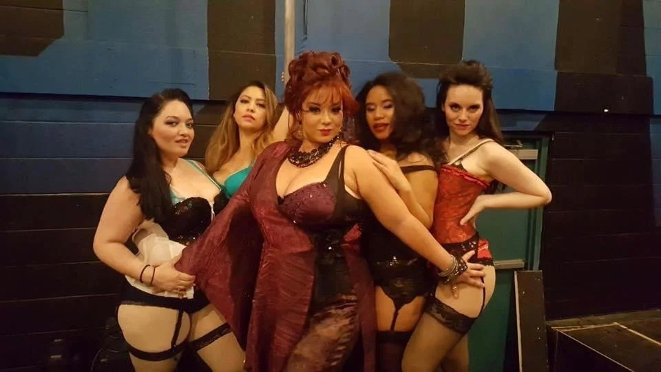 ROCK OF AGES a rock musical at Manoa Valley Theatre. Group of five women dressed in burlesque-style costumes posing together against a dark background. Hawaii actresses.