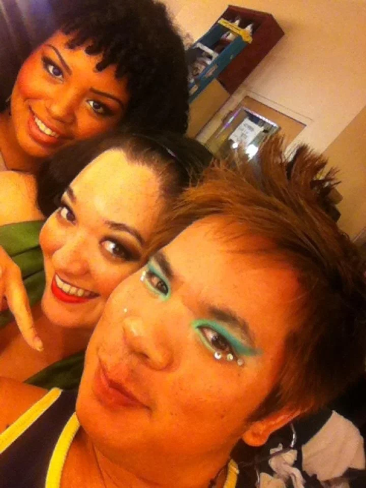 LITTLE SHOP OF HORRORS a comedic musical at Manoa Valley Theatre. Three actors backstage taking a close-up selfie indoors with makeup and smiling with dressing room lights.