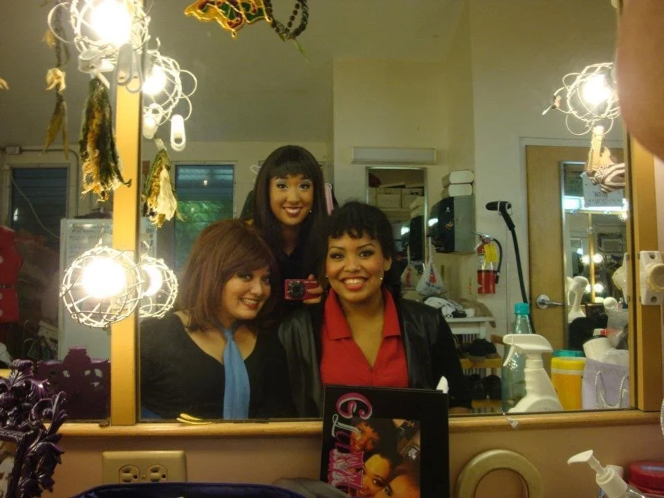 LITTLE SHOP OF HORRORS a comedic musical at Manoa Valley Theatre in Honolulu, Hawaii. Three women posing for a mirror selfie in a dressing room with makeup and hair products on the counter.