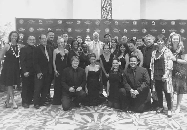 FROM HERE TO ETERNITY W/SIR TIM RICE in Honolulu, Hawaii. Group of people dressed in formal attire, posing for a photo at an event with a decorated backdrop.