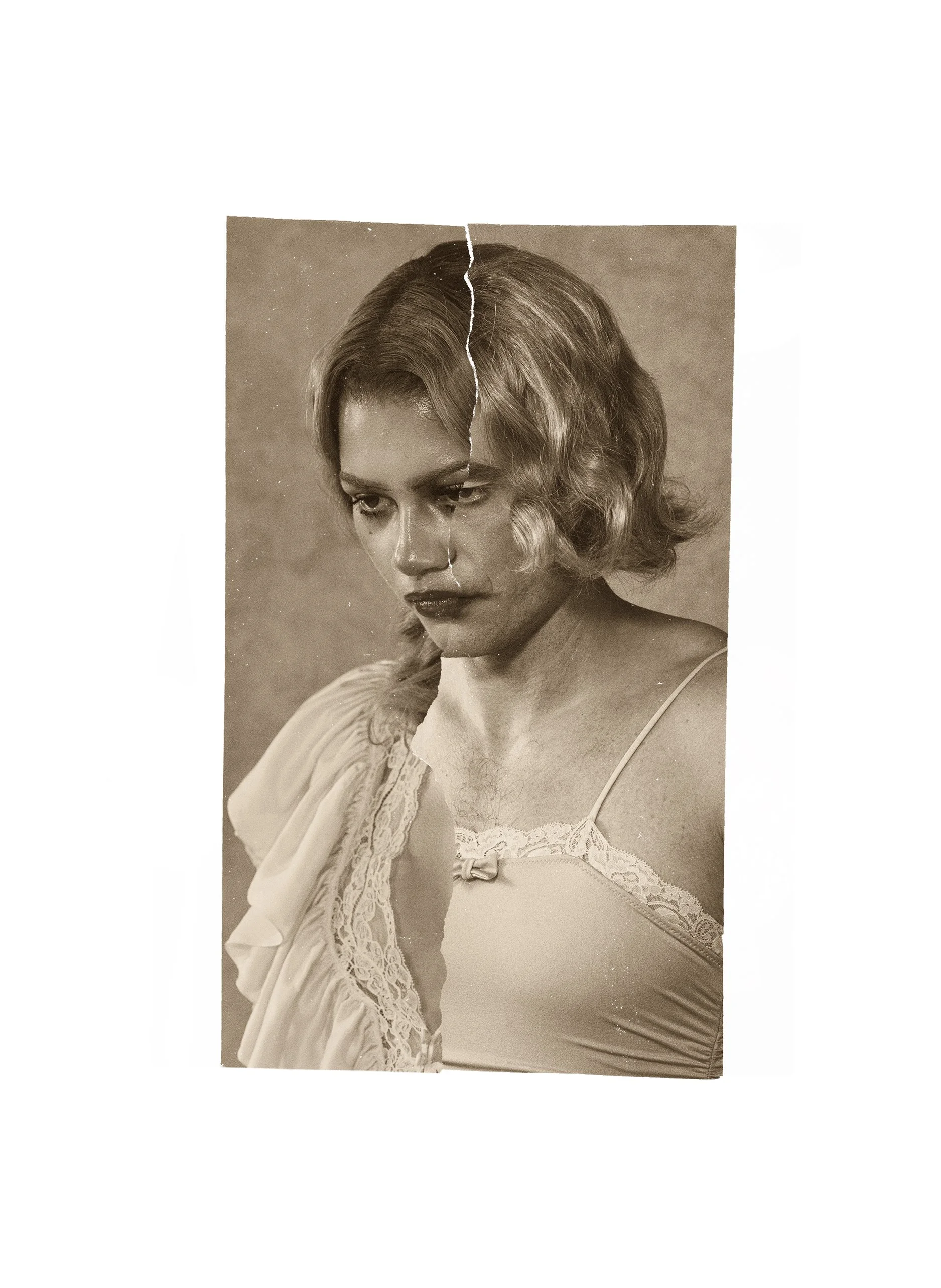 A black and white photograph of a woman with wavy, shoulder-length hair, wearing a lace-trimmed top or nightgown, looking downward with a serious expression.