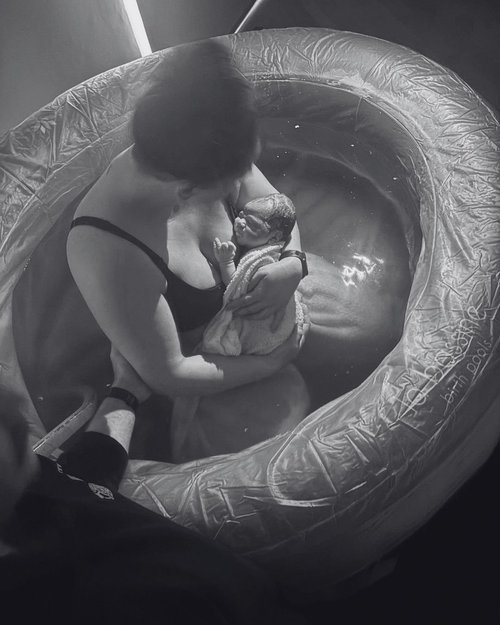 Bec holding her baby in a birth pool