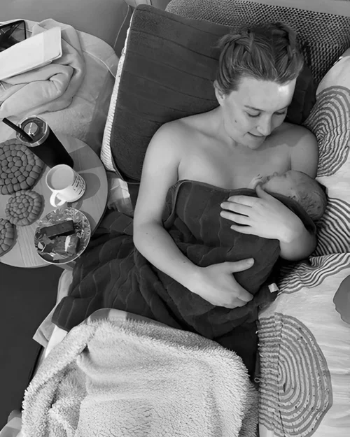 Katie feeding her newborn in bed