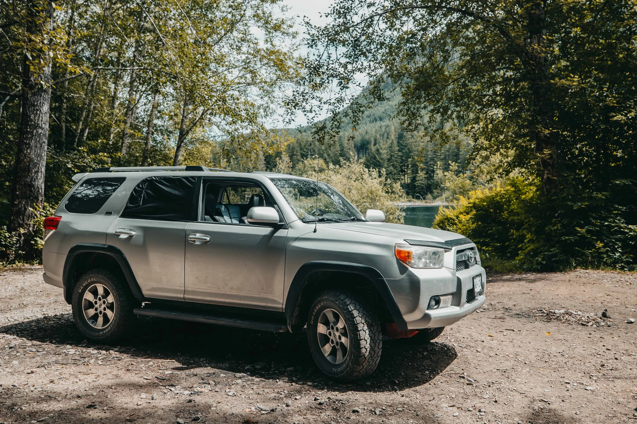 a toyota 4runner parked in a campsite next to a remote backcountry lake on vancouver island british columbia