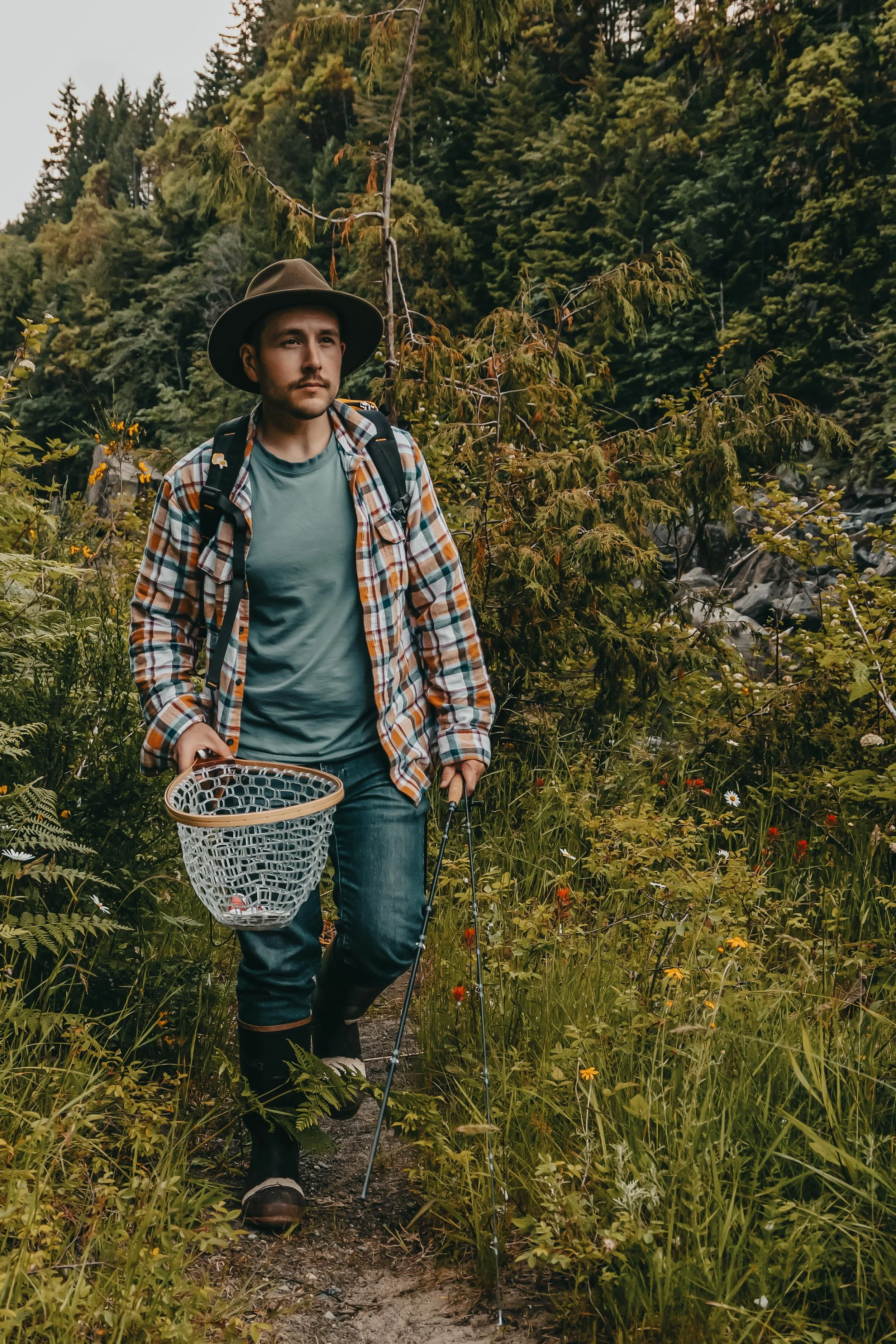 portrait of a man in a hat carrying fishing rods and a net to the river, Nanaimo British Columbia