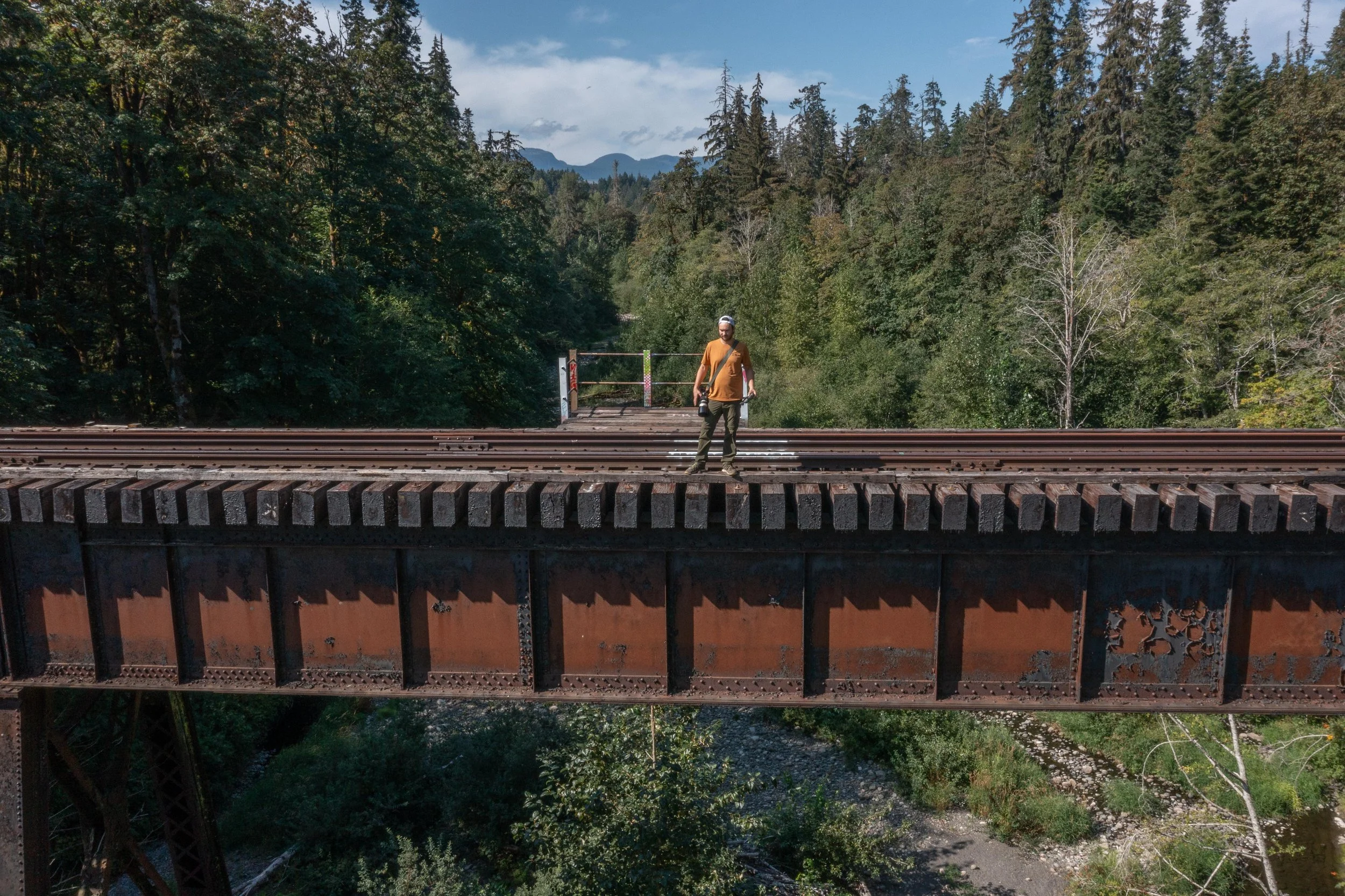 man standing at the edge of the Trent river trestle in Royston BC, Dylan Phillips Photography