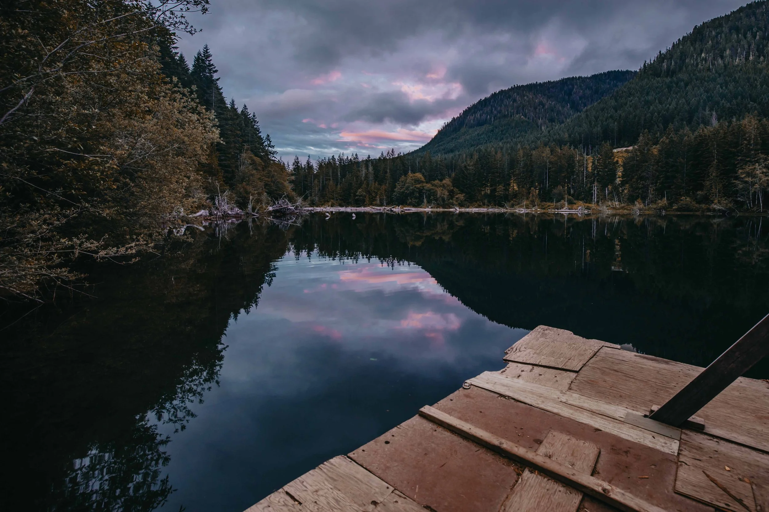 pink clouds reflect in the water of an alpine lake at sunset on vancouver island british columbia