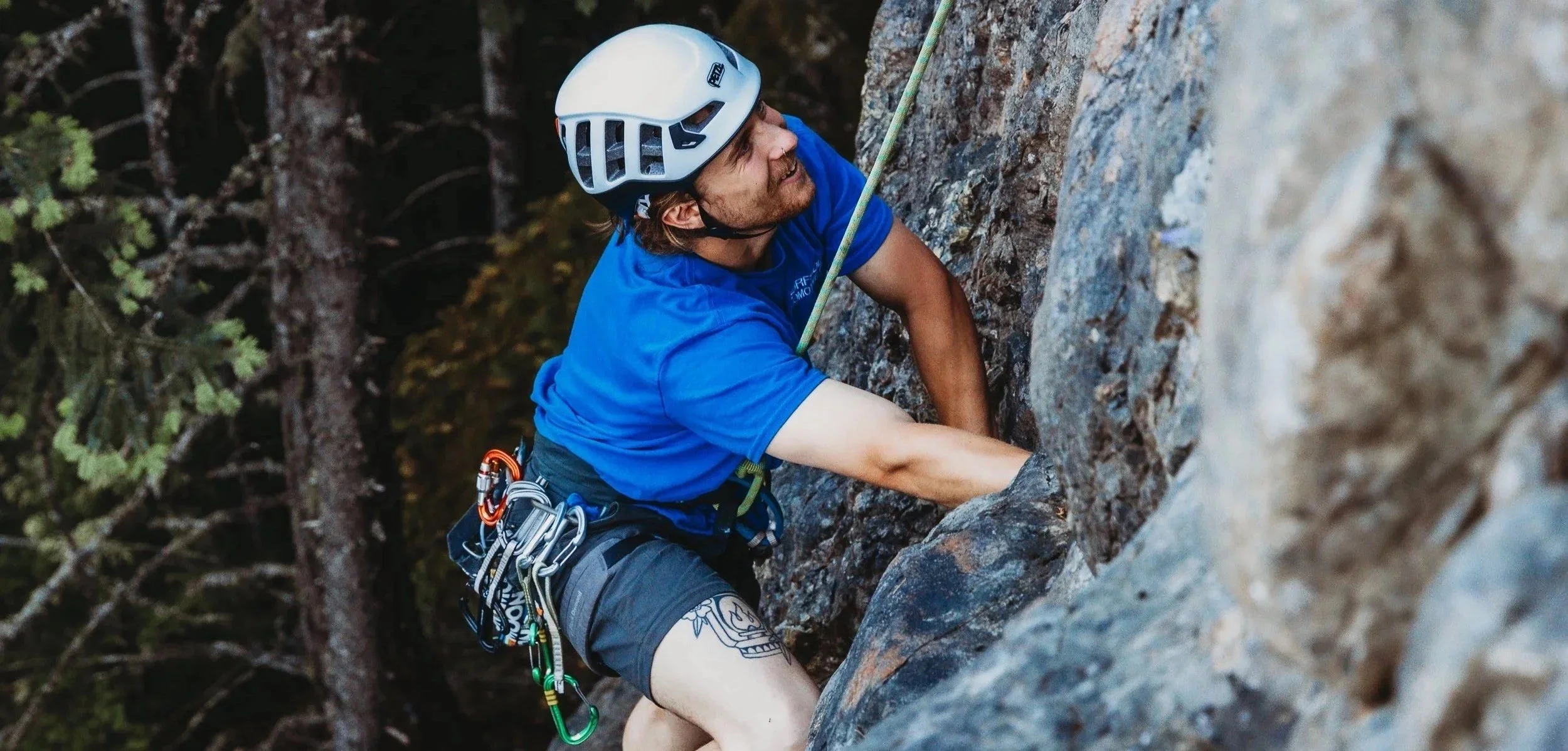 man in a blue shirt rock climbing on mount benson, Nanaimo BC, Canada