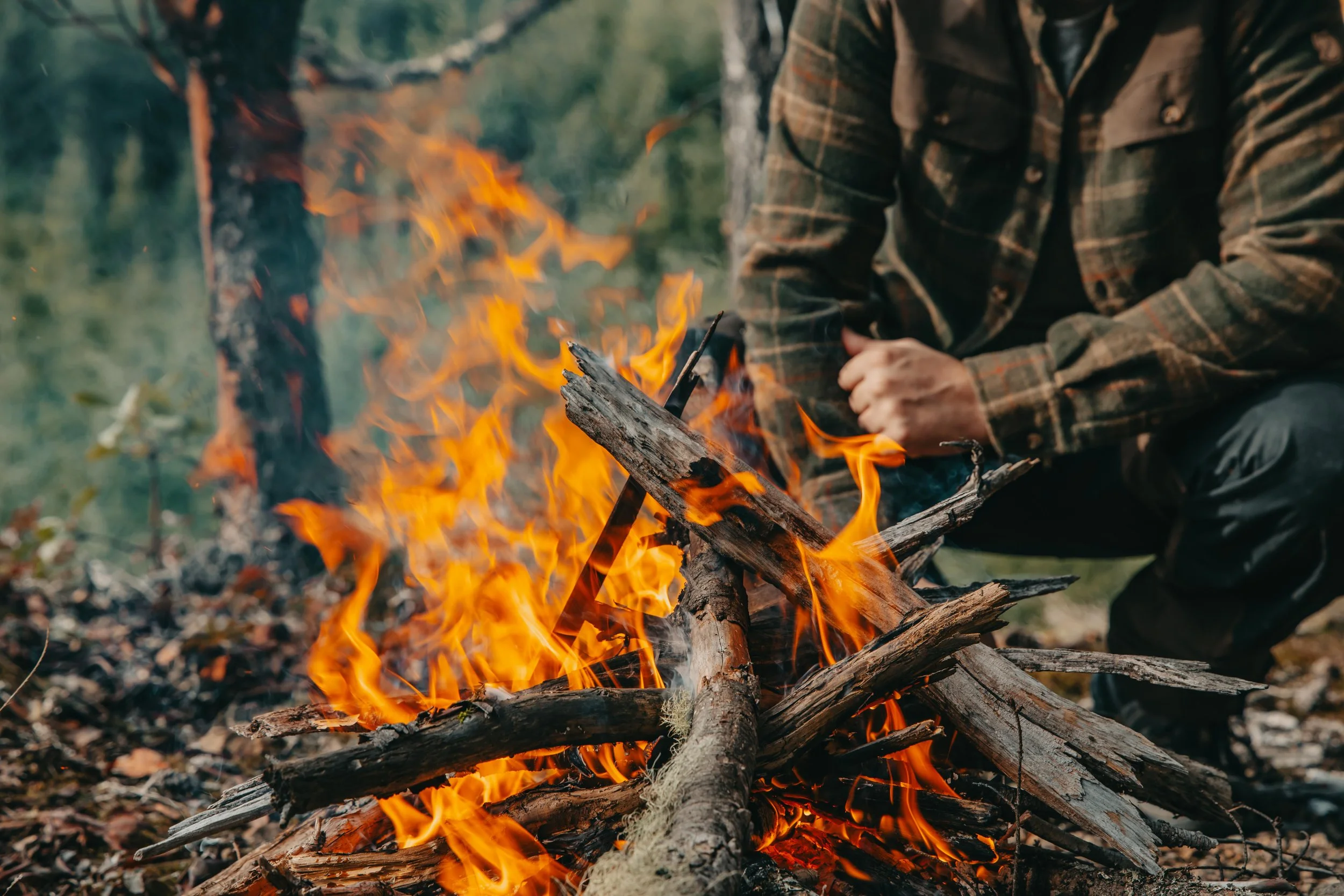 close up of a campfire with a man in the background, vancouver island BC