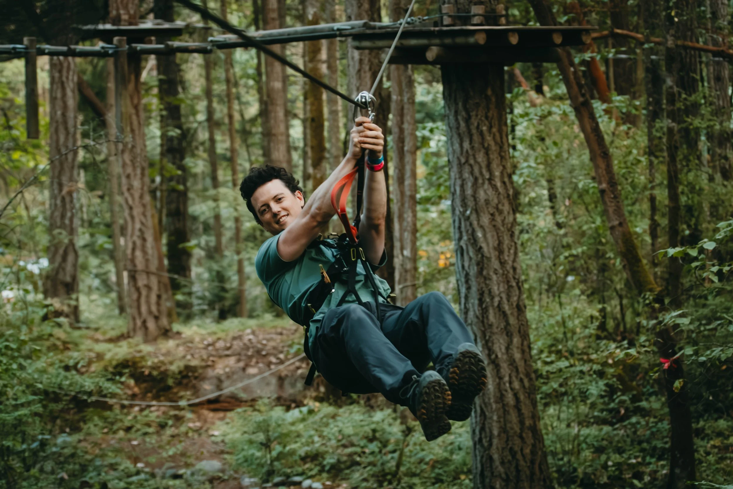 man in a green shirt ziplining at wildplay adventure park in Nanaimo, British Columbia