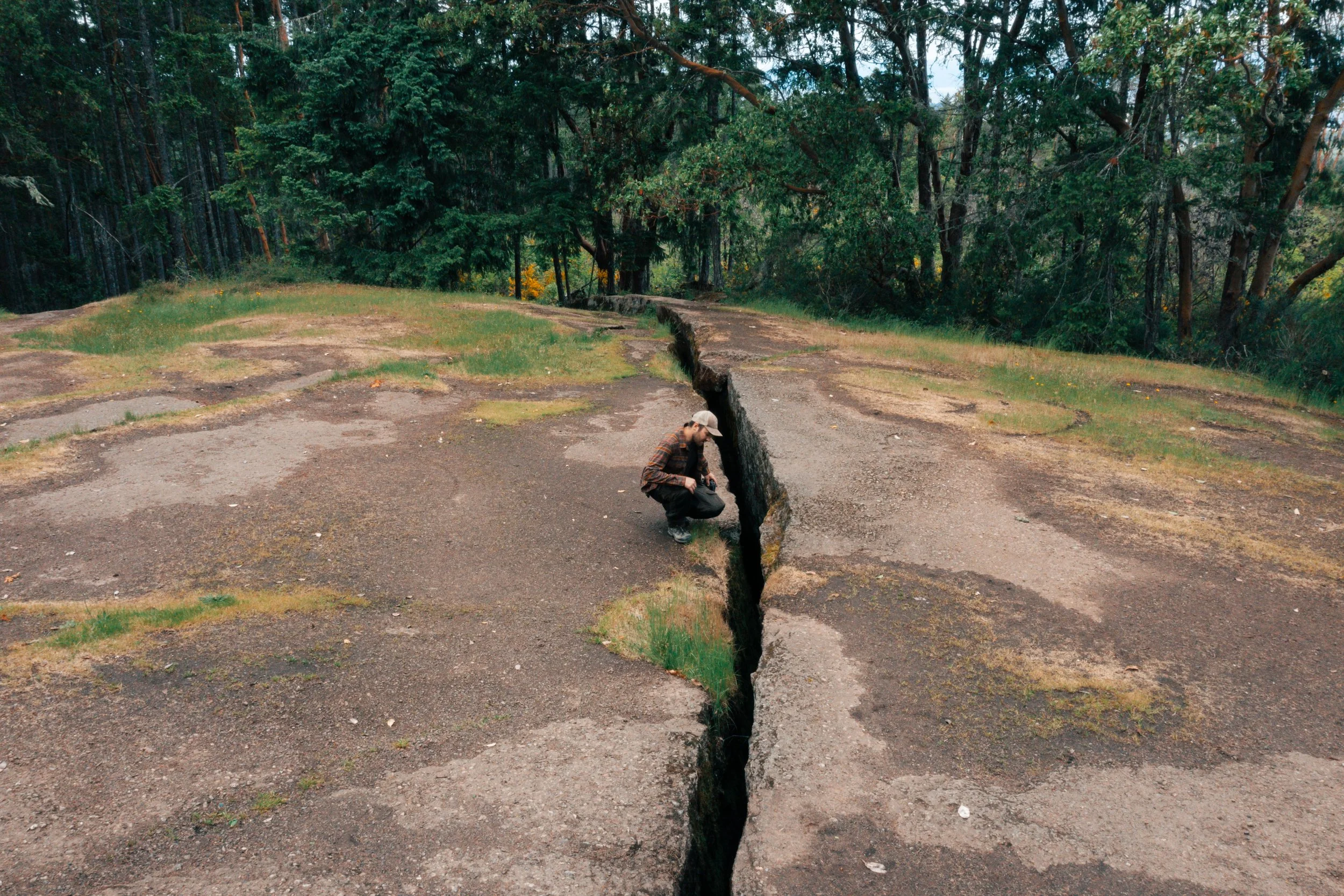 A man standing near the edge of The Abyss in Nanaimo, BC, showing the scale of the massive crack in the earth along this Vancouver Island hiking destination.