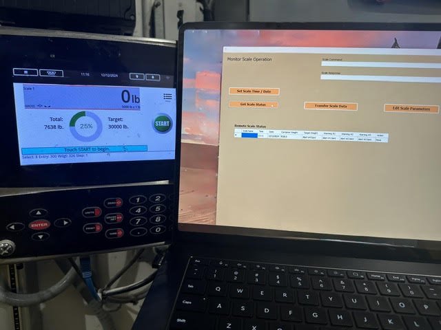 A digital scale display showing 0 pounds with a target of 30,000 pounds, and a laptop screen with scale operation software open.