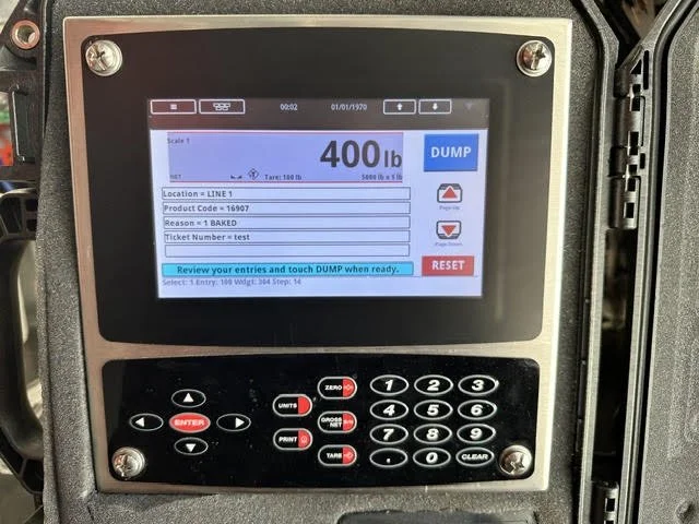 Digital weight scale display showing 400 pounds with an option to dump or reset, surrounded by a keypad and control buttons.