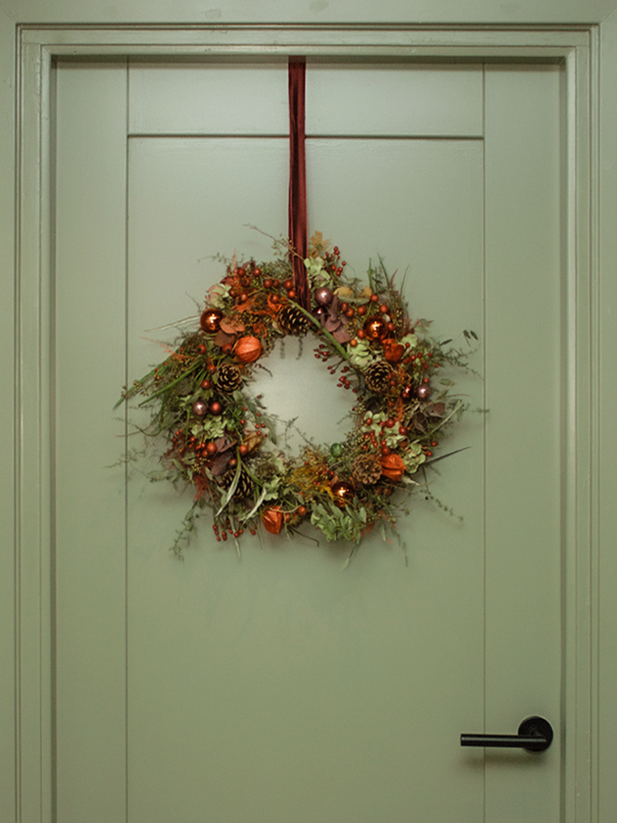 Kerst- of adventskrans hangend aan een deur.