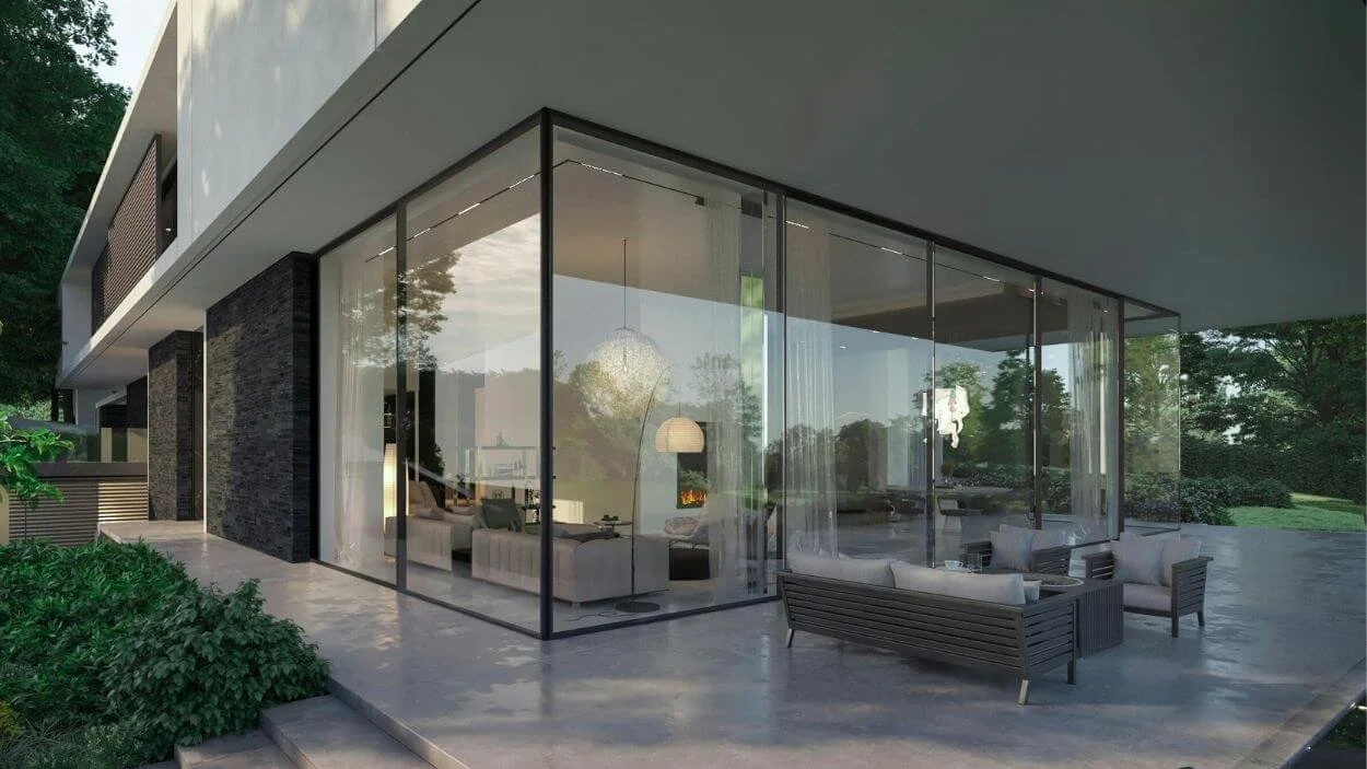 Exterior view of a luxurious, modern home featuring floor-to-ceiling glass walls on two sides, offering a view of the minimalist, light-toned living room interior, for "Green & Pine" a custom builder/architecture website template.
