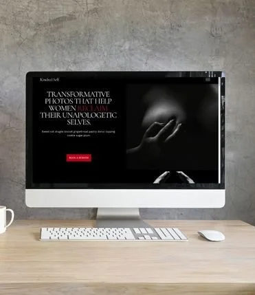 Desktop monitor displaying a boudoir photography website template. The screen shows a dark hero section with the headline "TRANSFORMATIVE PHOTOS THAT HELP WOMEN RECLAIM THEIR UNAPOLOGETIC SELVES" and a red call-to-action button.