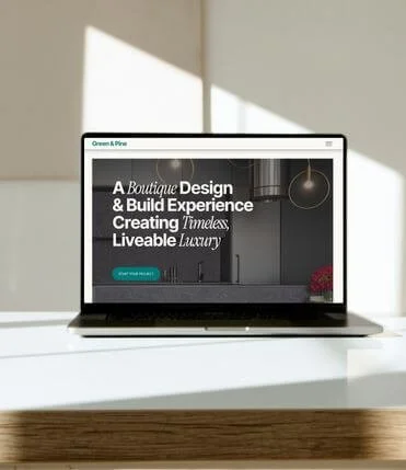 Laptop screen displaying a custom builder/architecture website template. The hero image features a high-end kitchen interior with bold white text: "A Boutique Design &